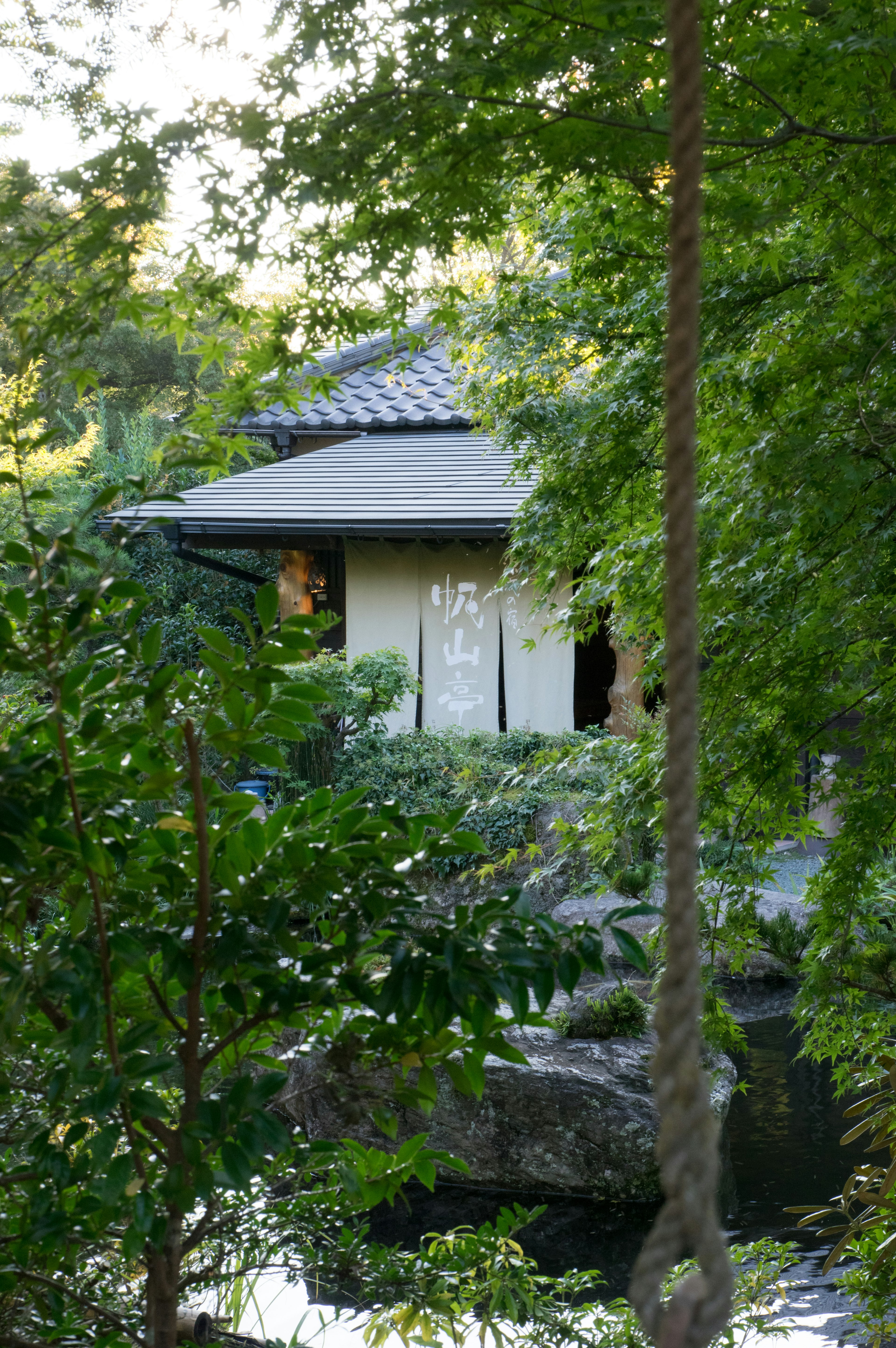 Rumah tradisional Jepang dikelilingi oleh hijauan subur