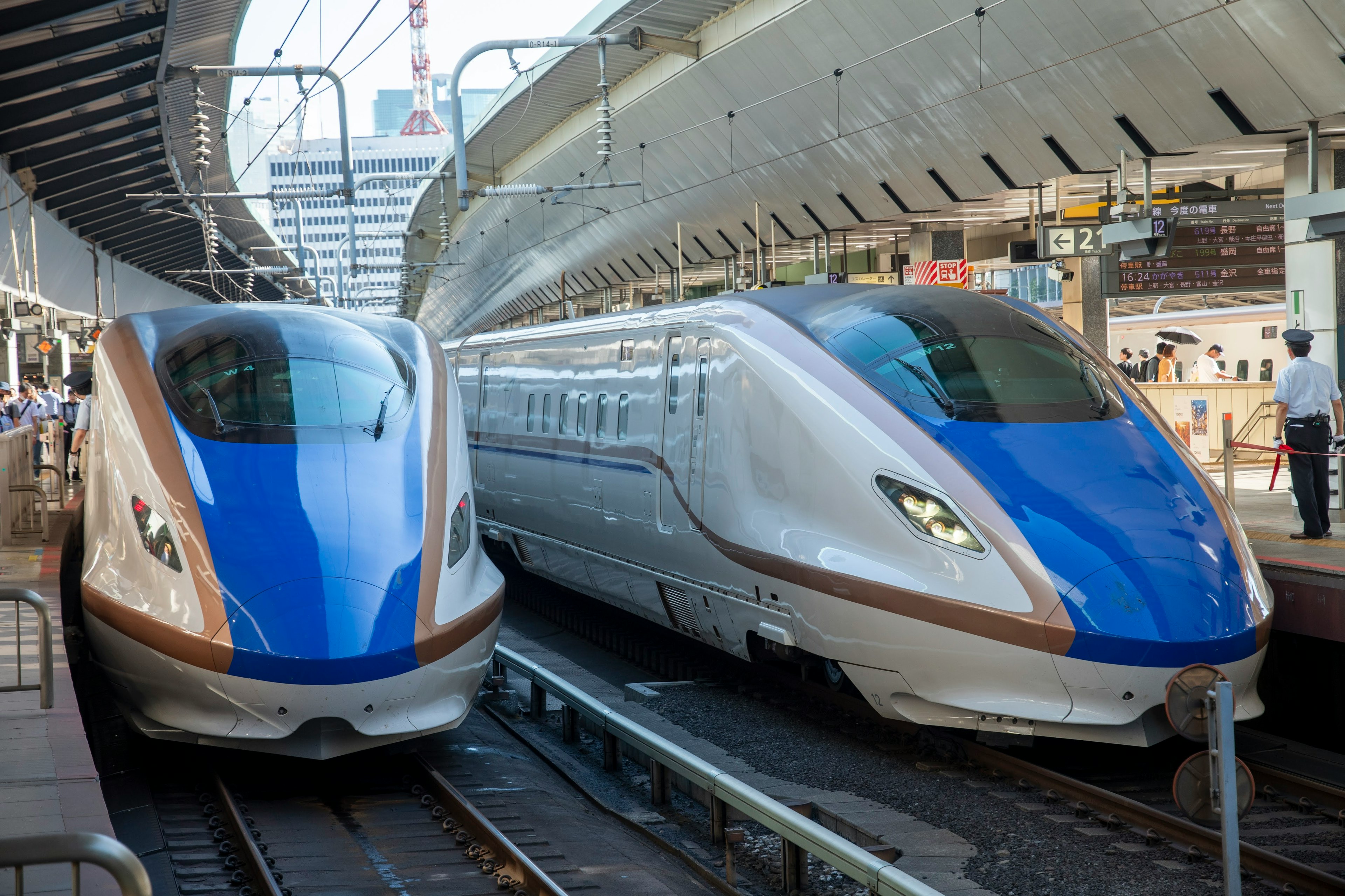 Zwei Shinkansen-Züge nebeneinander an einem Bahnhof