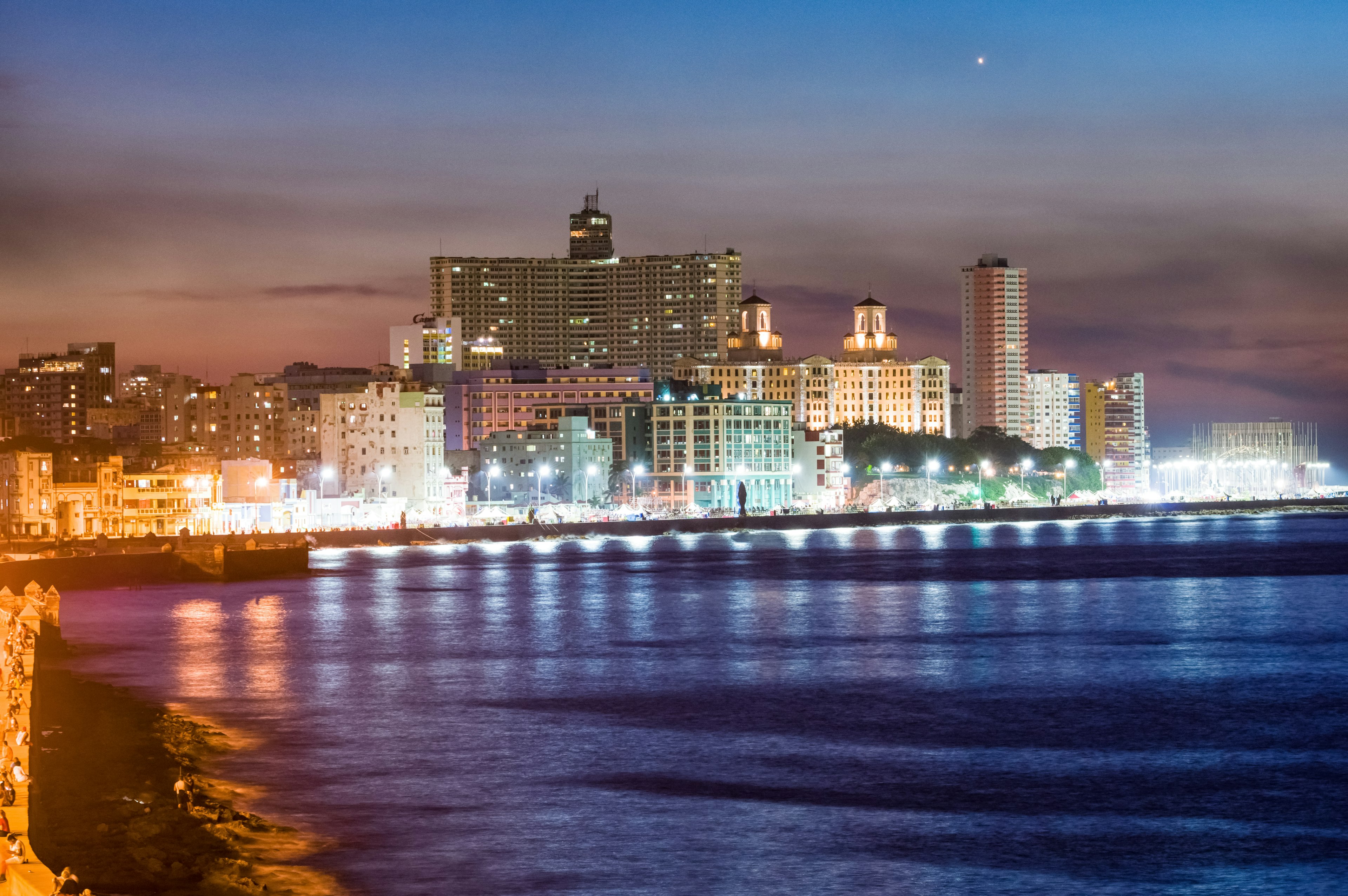 Hermosa vista nocturna del océano y el horizonte de la ciudad