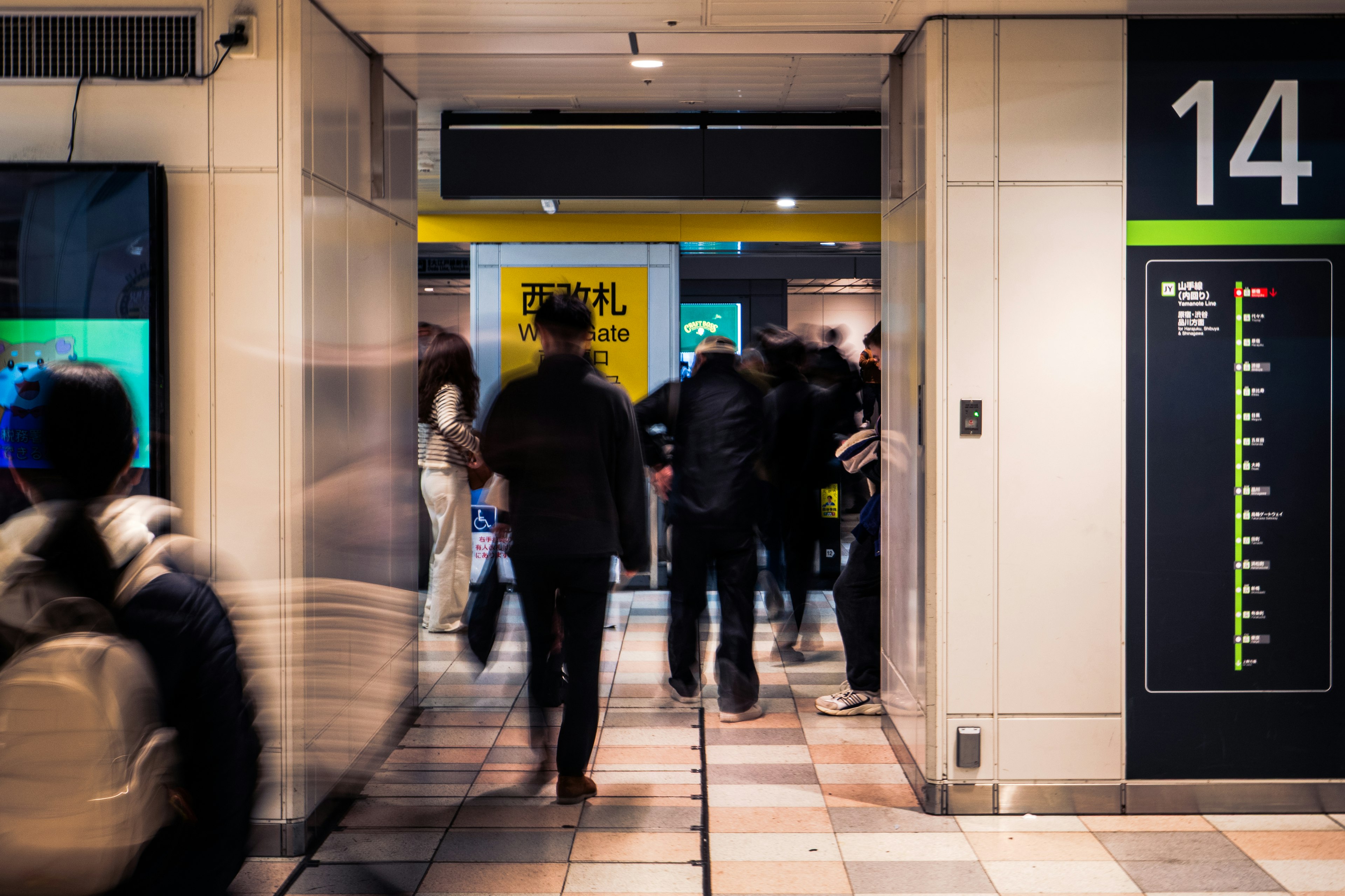 Koridor stasiun yang ramai dengan orang-orang dan tanda platform 14