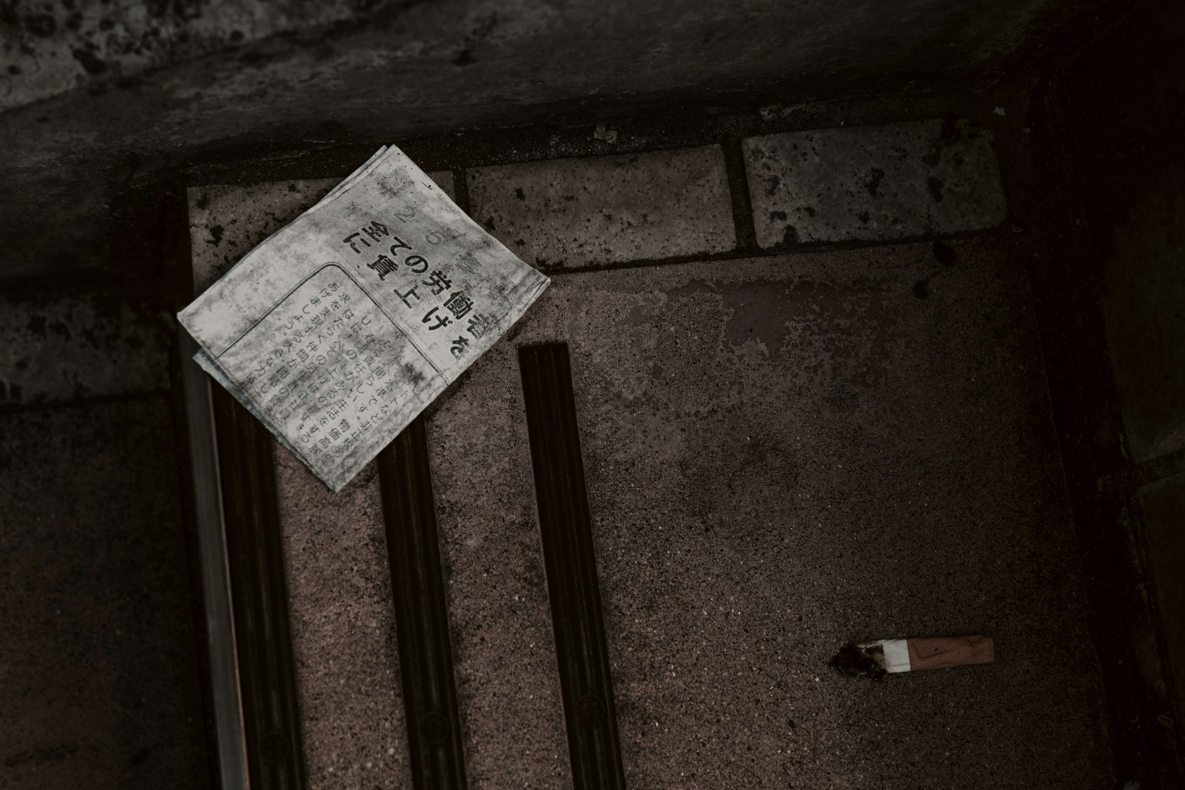 An old paper on the floor alongside several metal rods