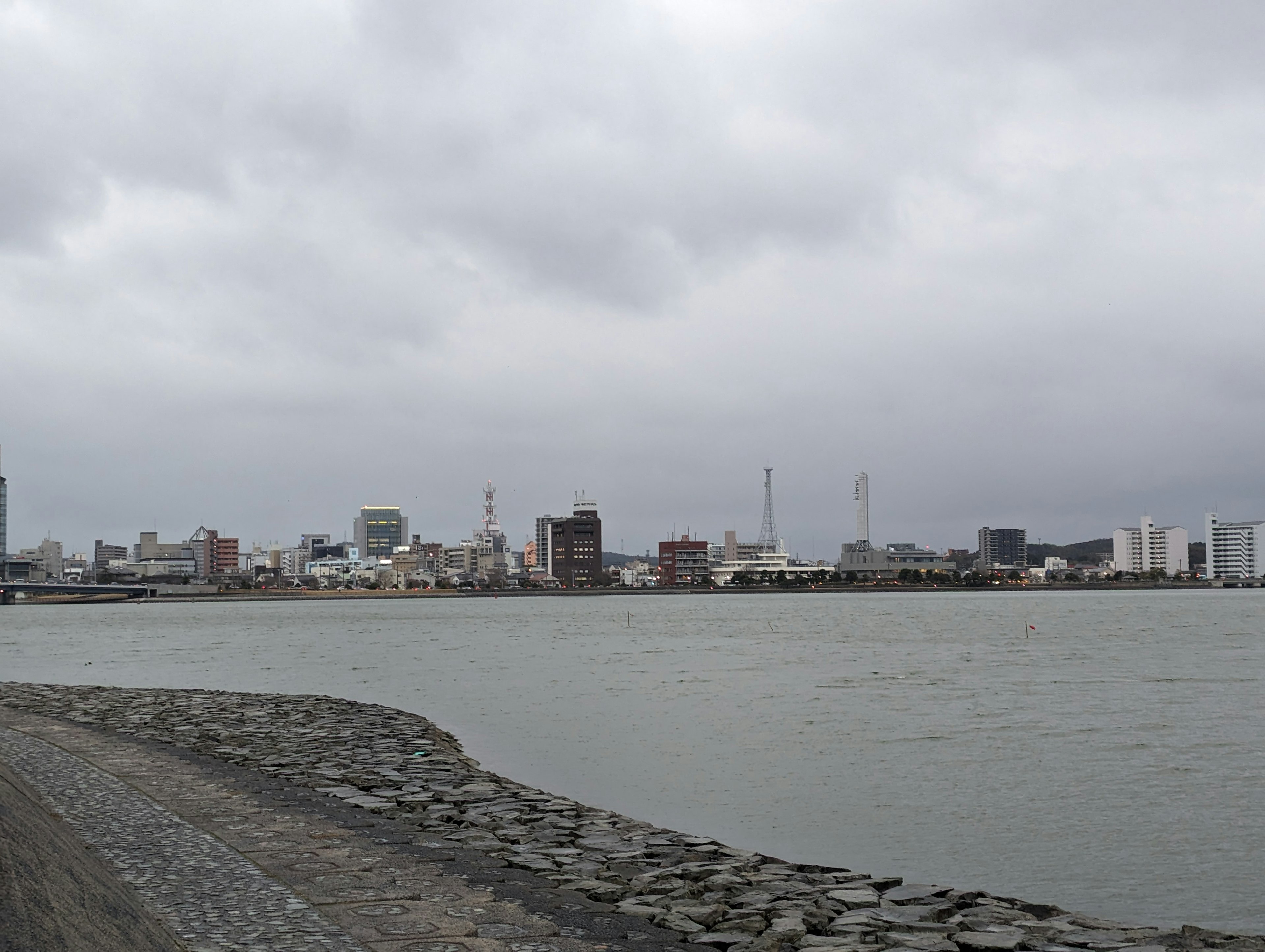 曇り空の下の海岸線と都市の風景