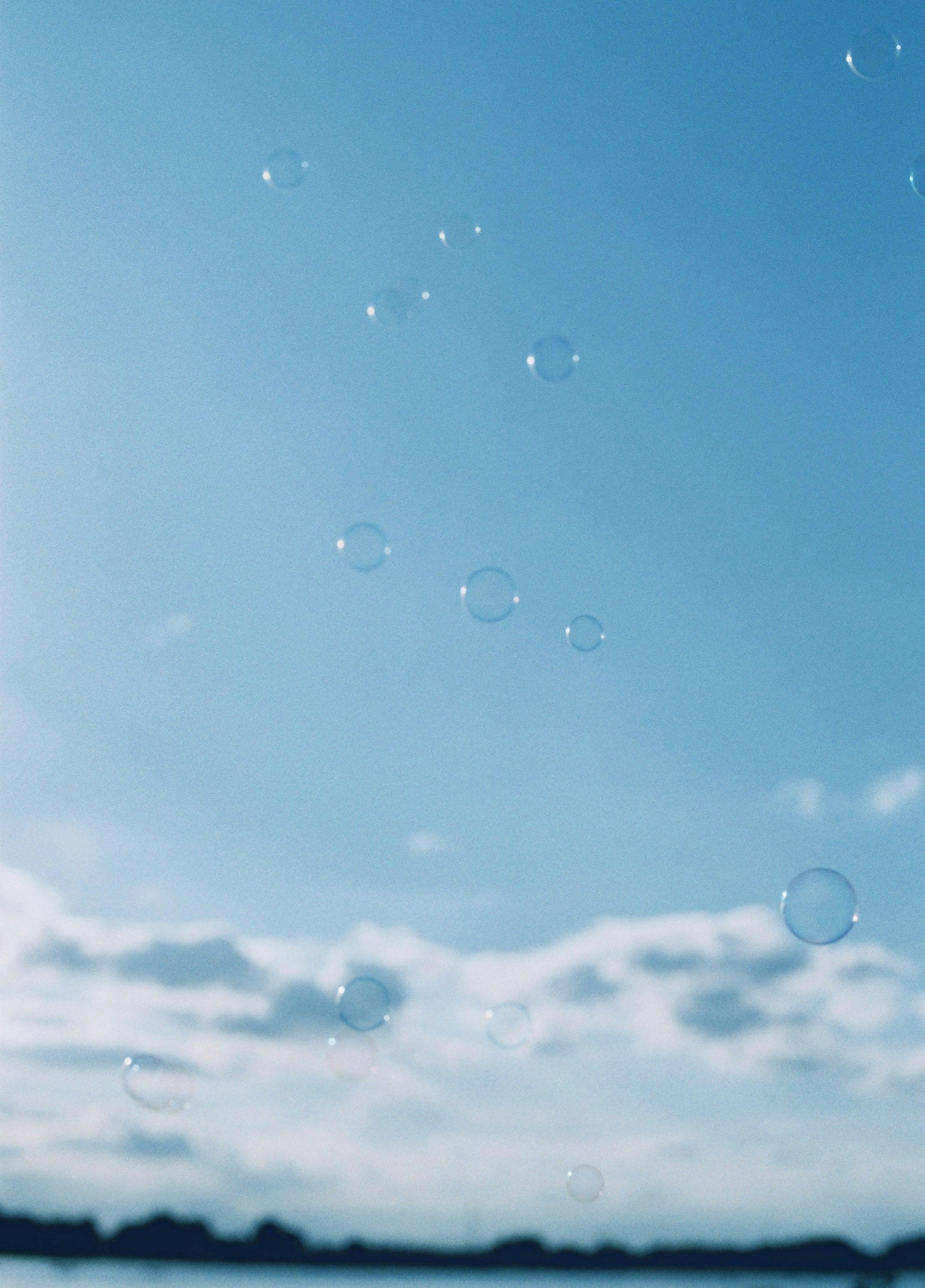 青空に浮かぶ泡と雲のイメージ