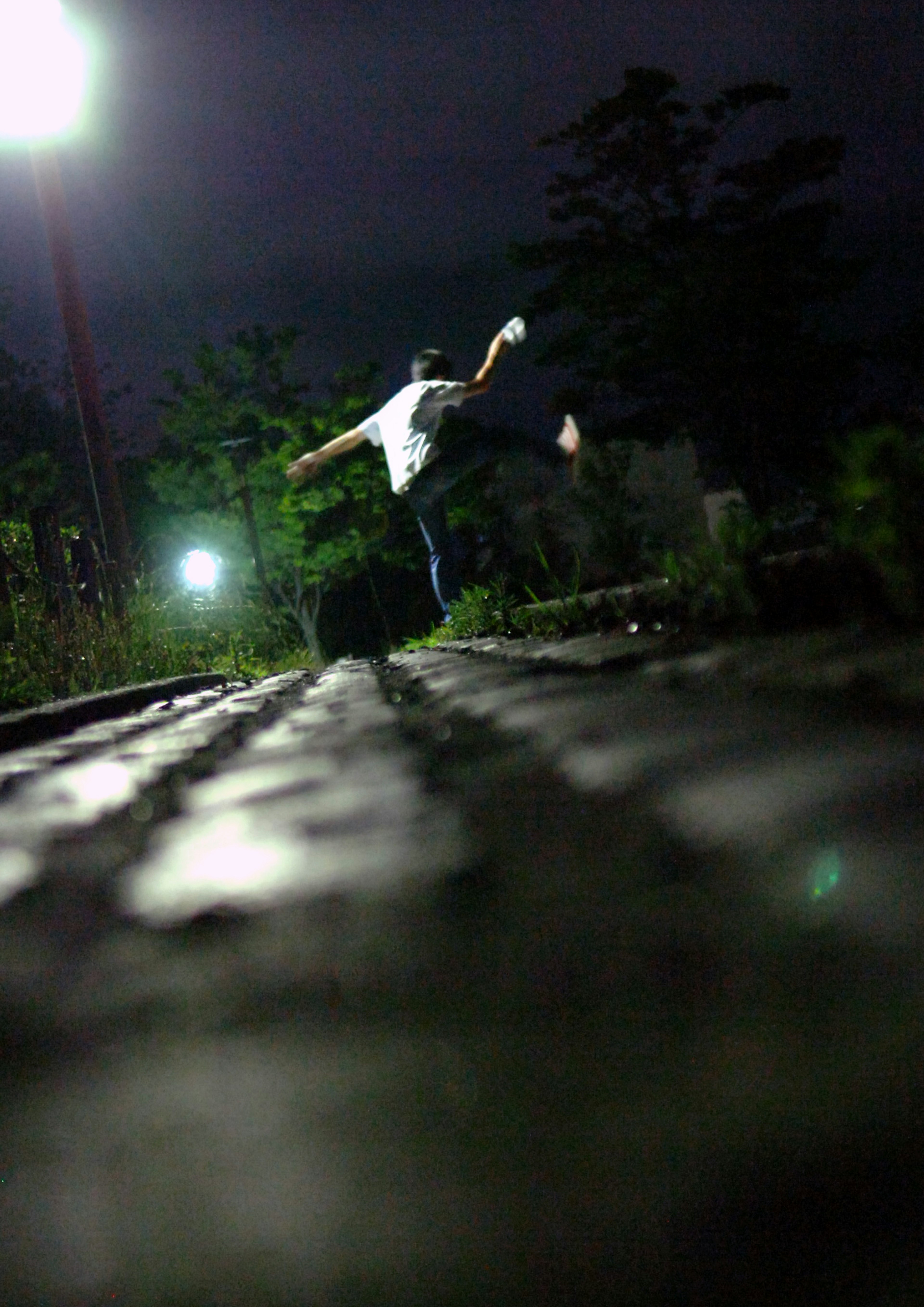 Silhouette di un giovane che fa skateboard su una strada notturna