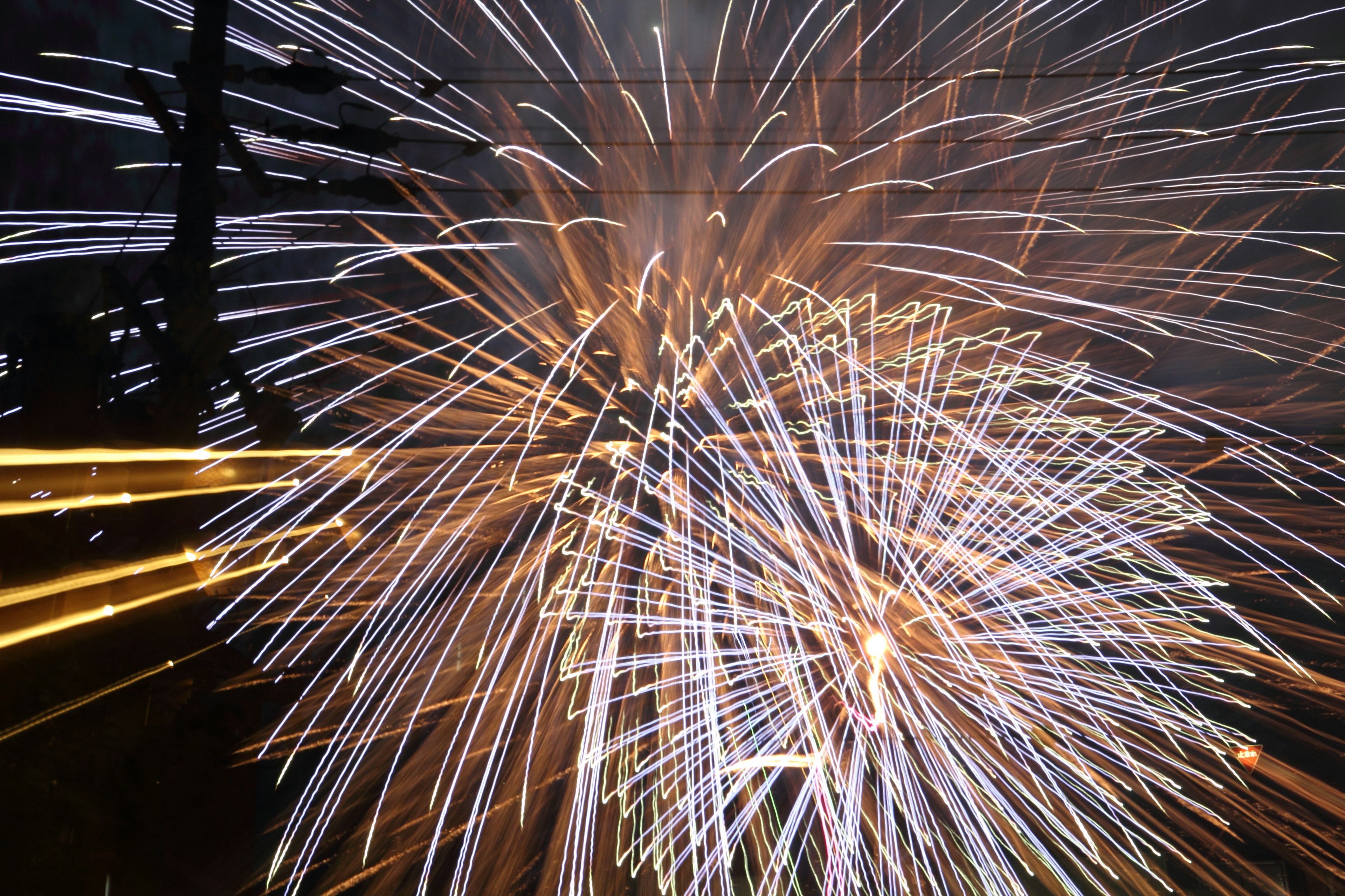 Feux d'artifice vibrants illuminant le ciel nocturne avec des traînées colorées