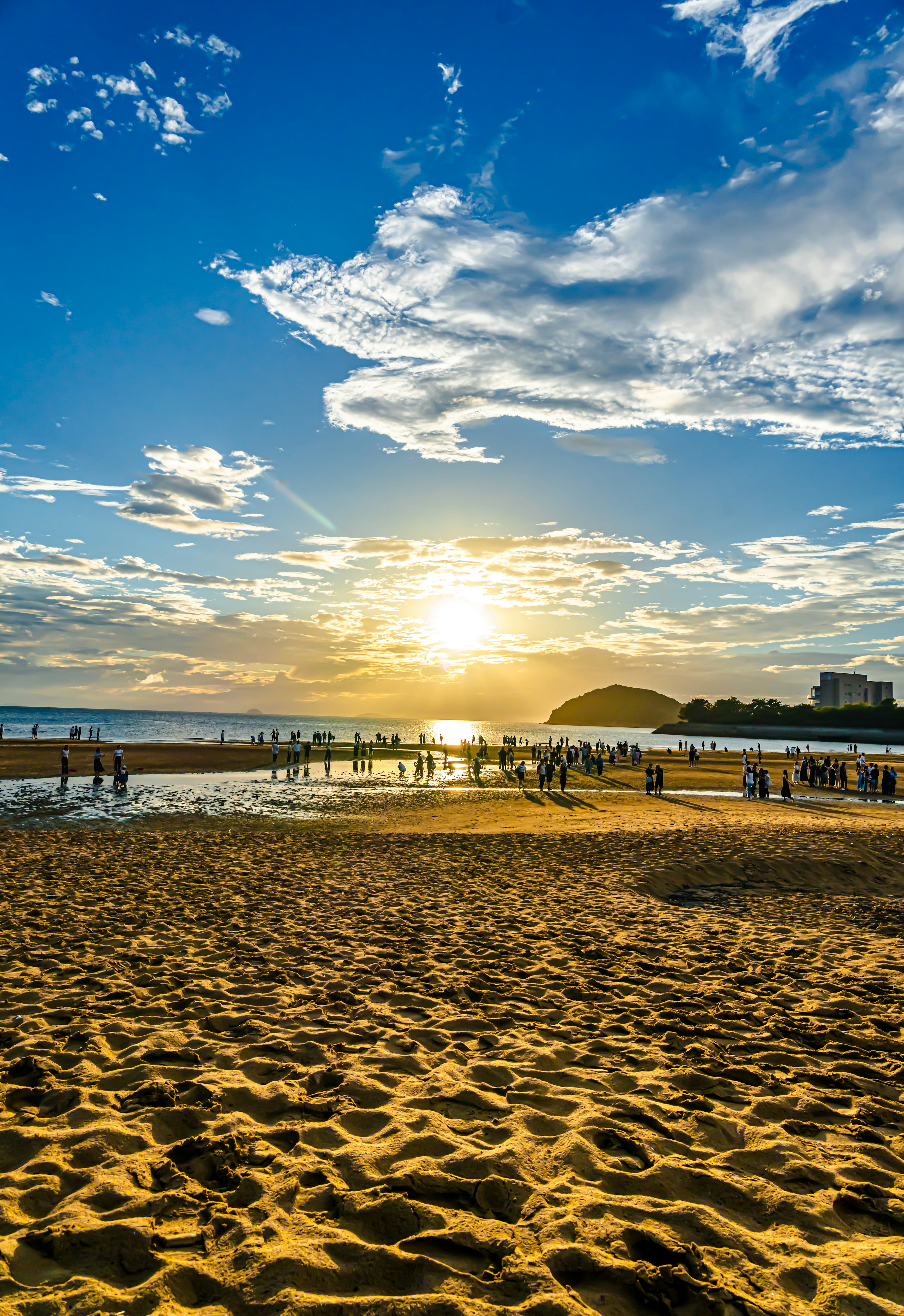 夕日が沈むビーチの風景砂浜と海人々が楽しむ