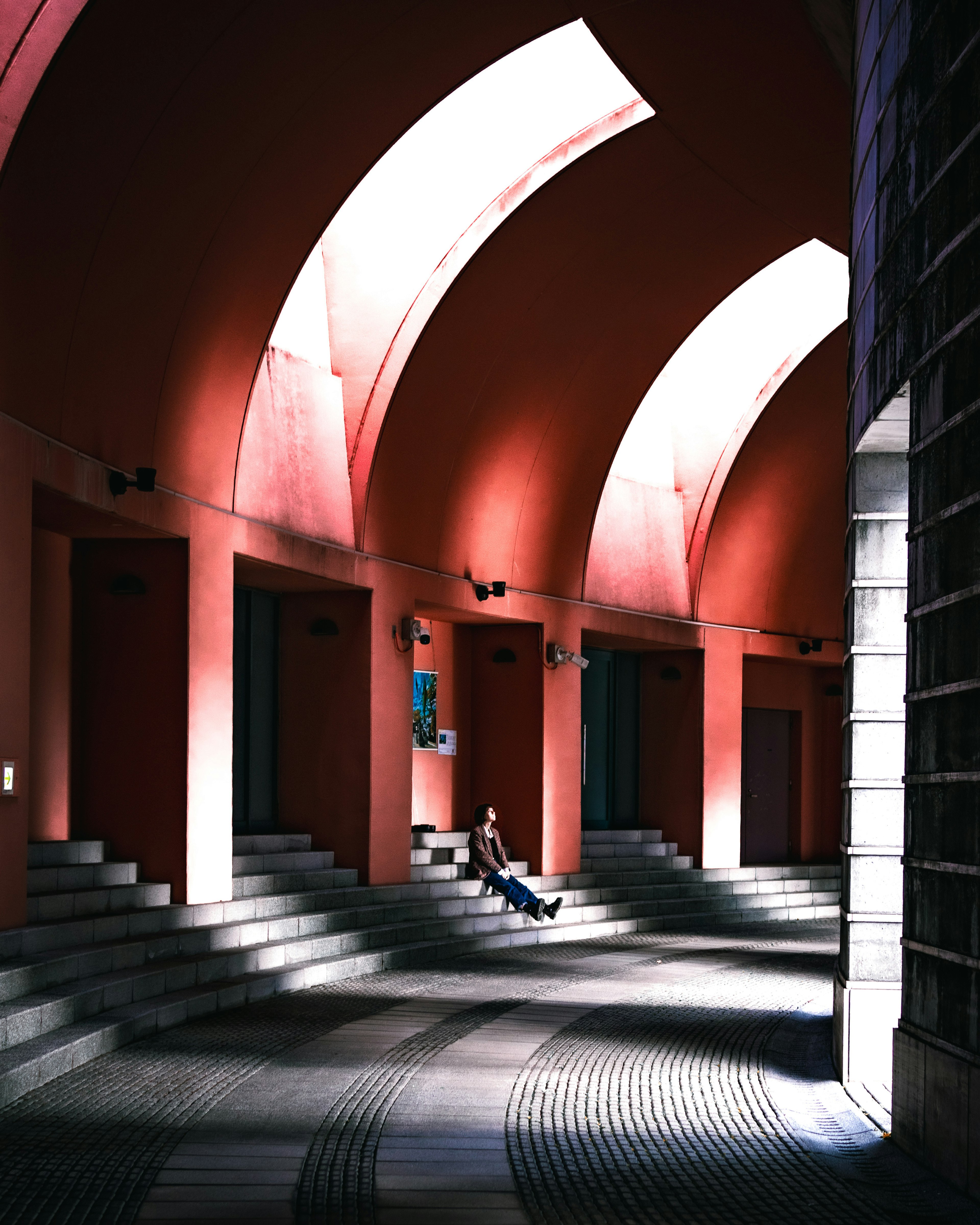 Interior of a building with red walls and arched ceilings Beautiful contrast of light and shadow