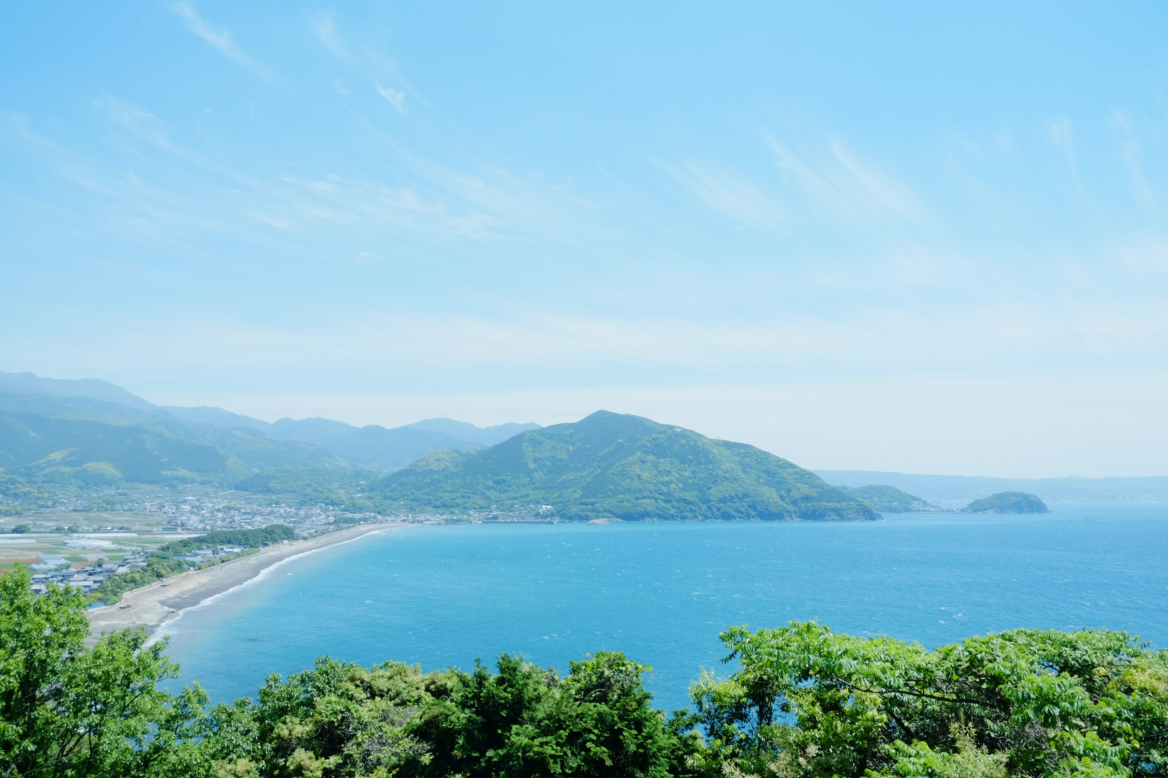 Scenic view of blue ocean and green mountains