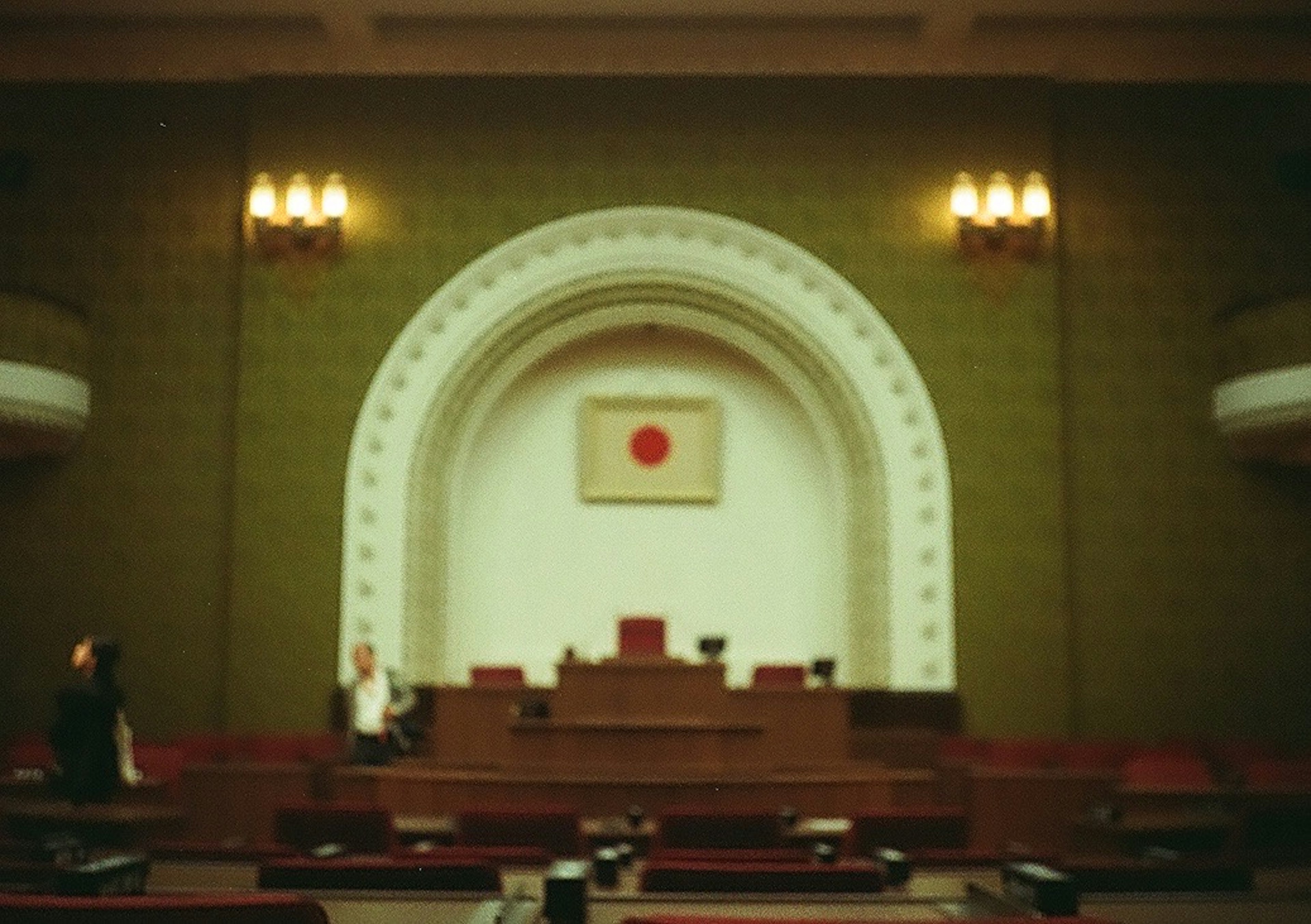 Interior of the Japanese National Diet featuring green walls and a red circle flag