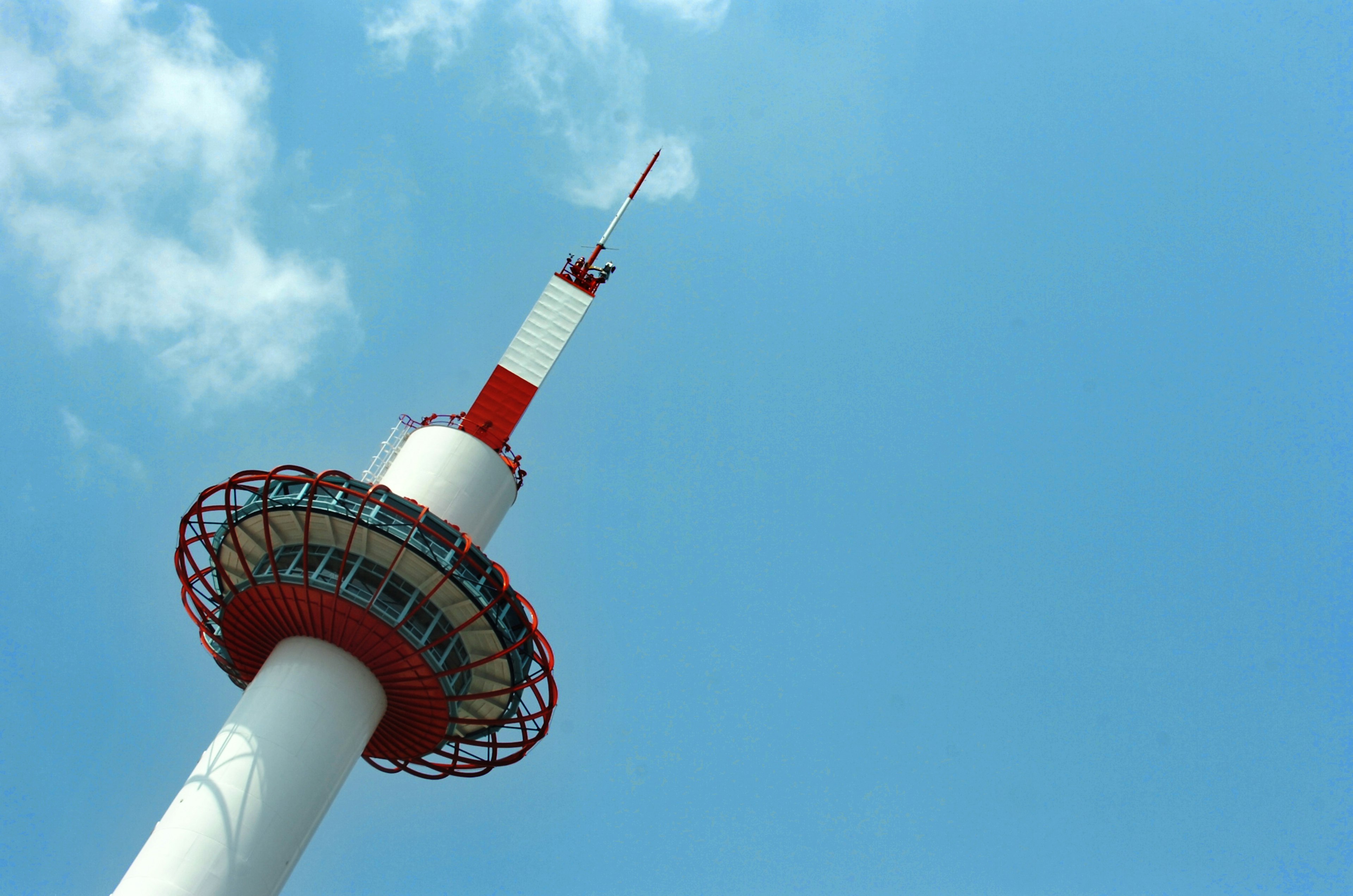 Tour de communication rouge et blanche sous un ciel bleu