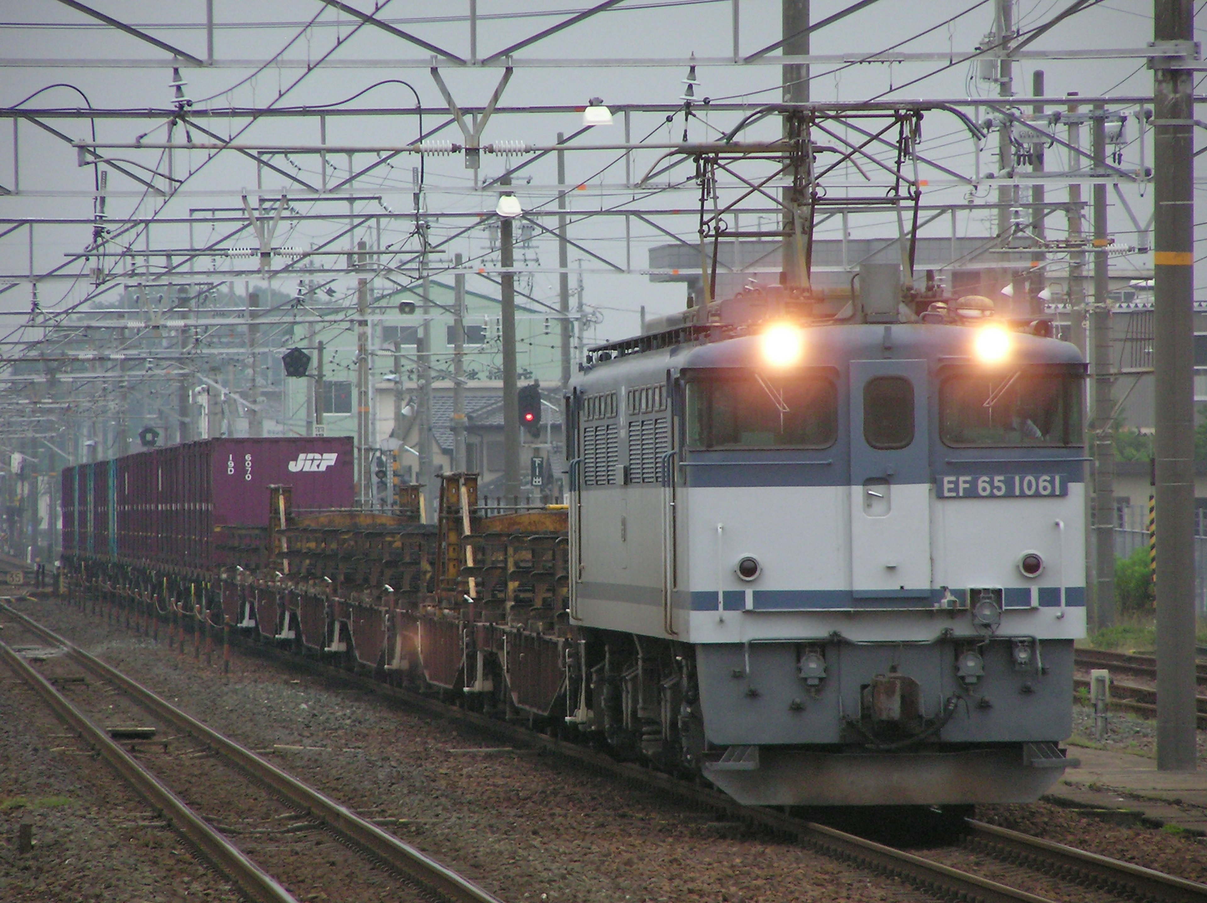 Freight train with electric locomotive running in fog