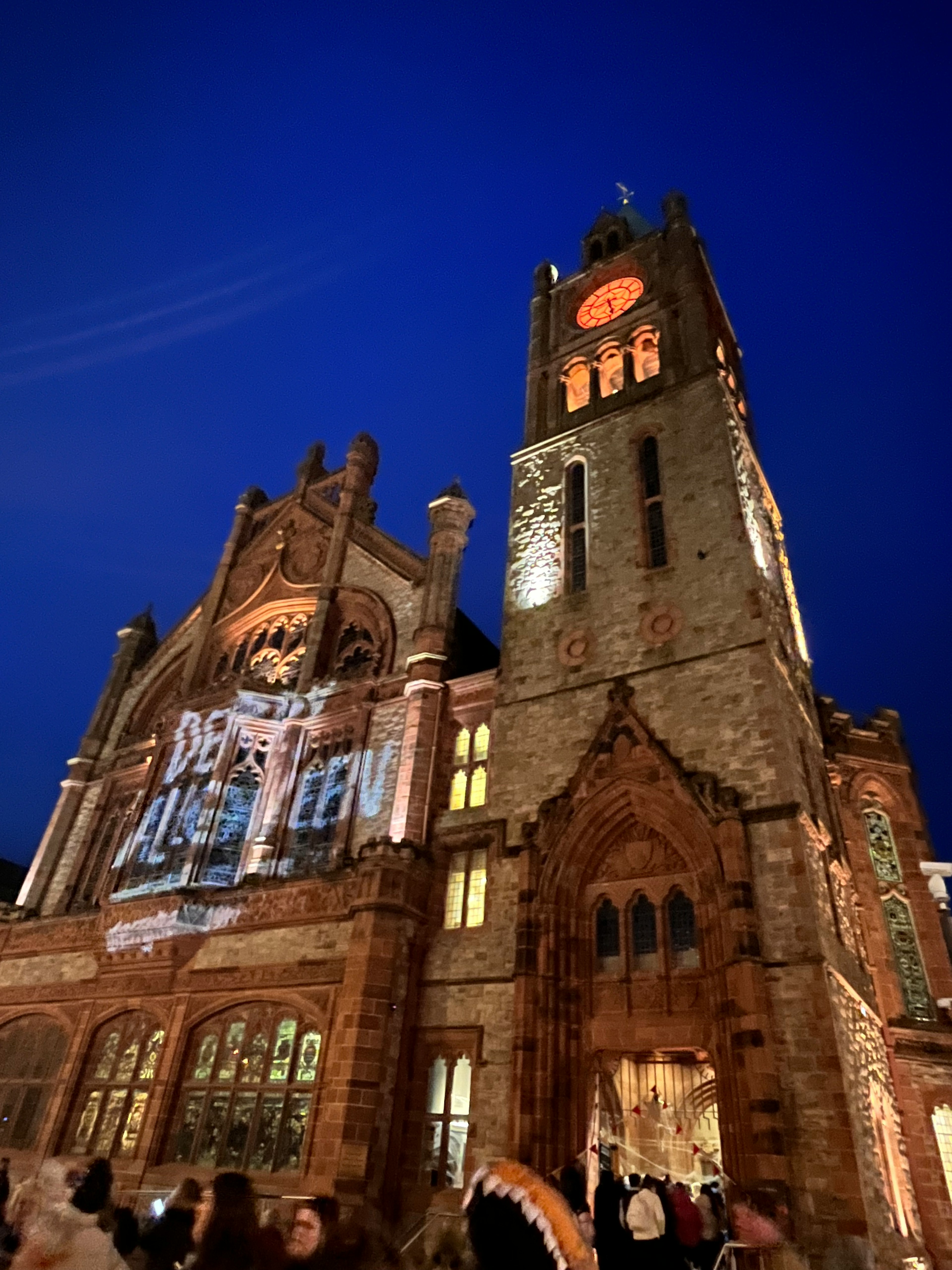 Historic building illuminated at night with blue sky backdrop