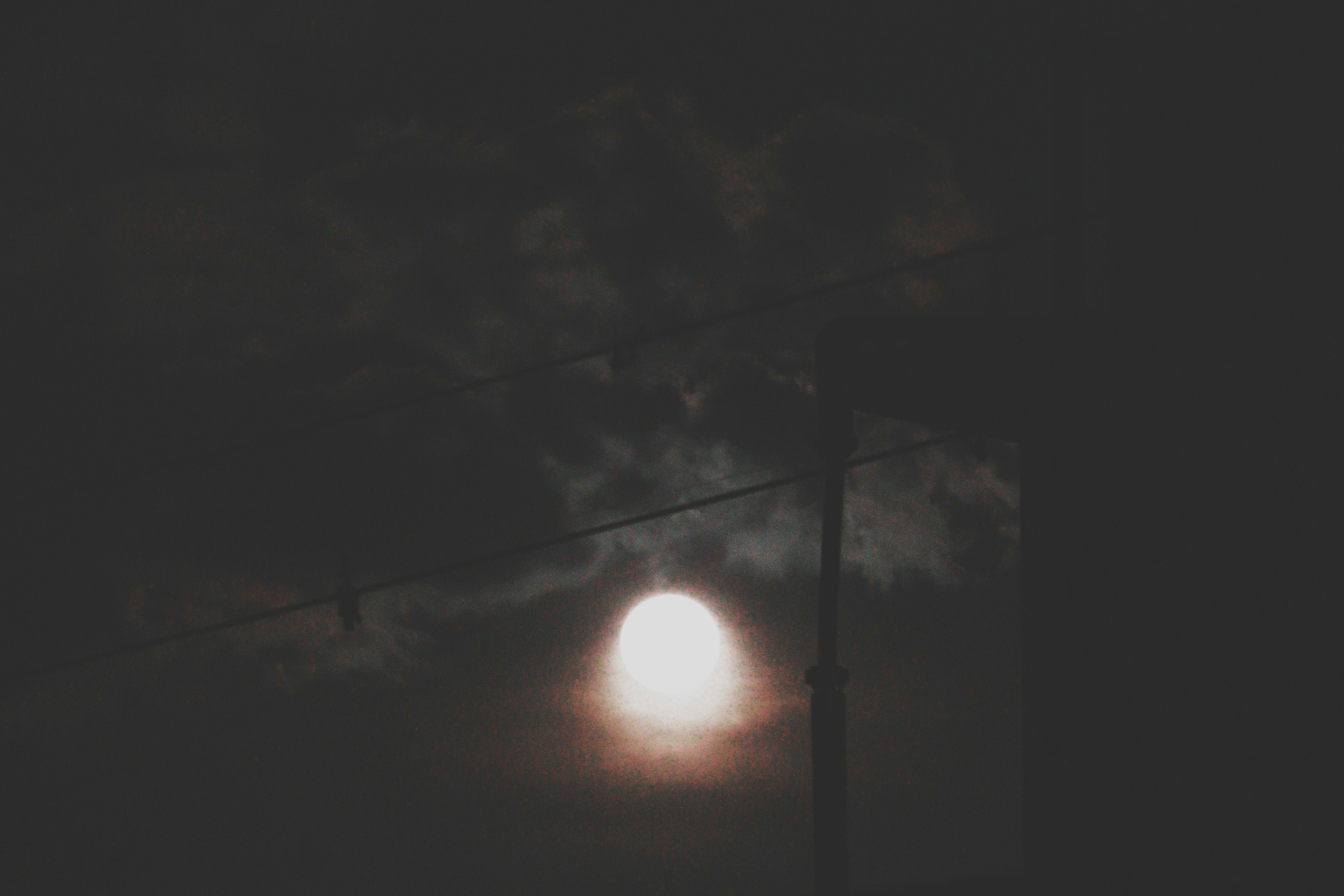 Grande lune brillante à travers des nuages sombres avec des silhouettes d'arbres