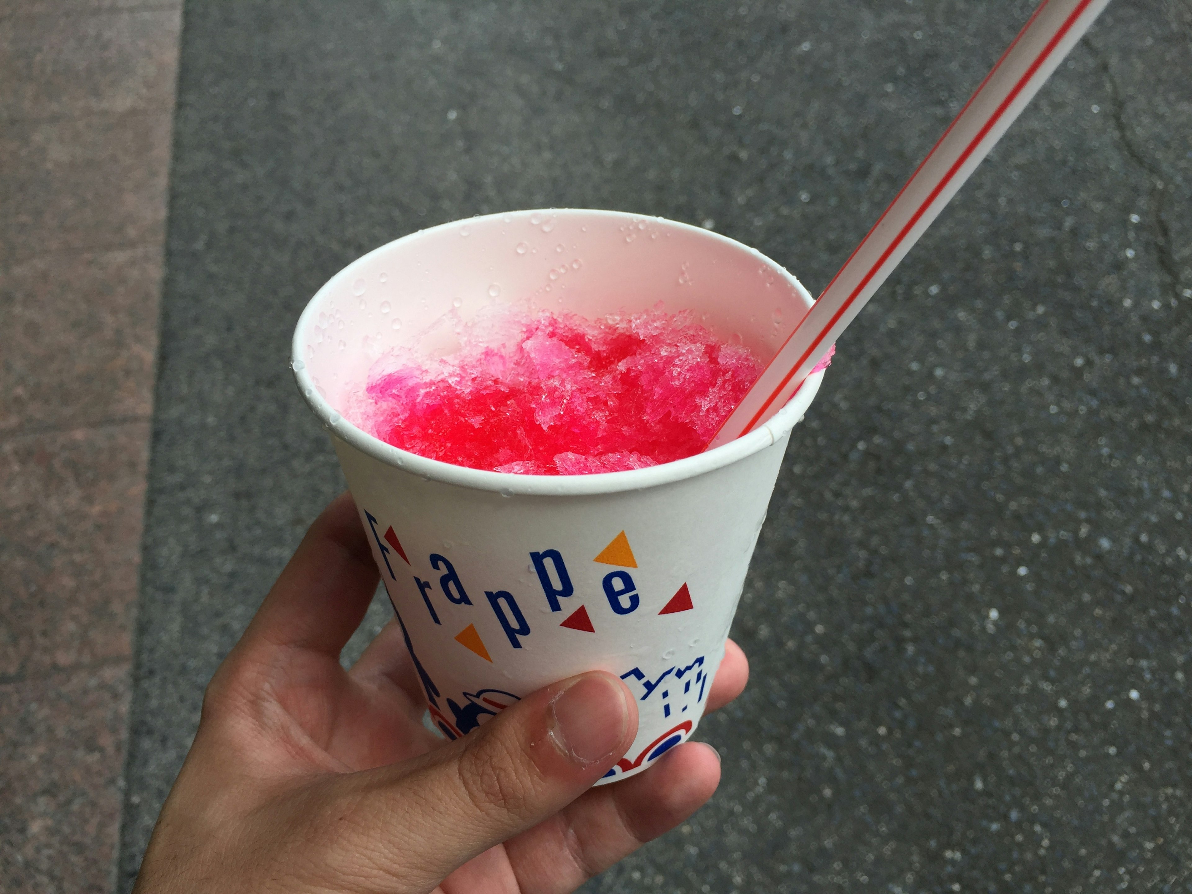 Hand holding a cup of red shaved ice