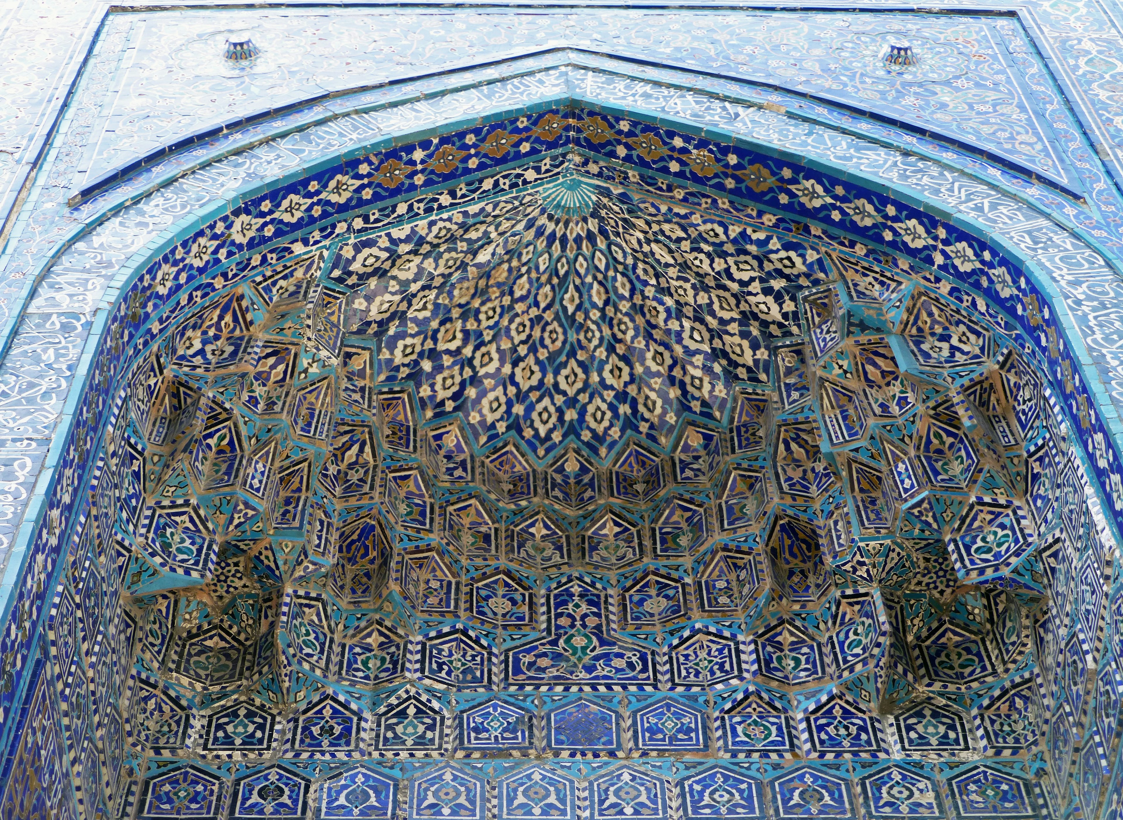 Intricate archway with blue tile patterns and detailed ceiling design