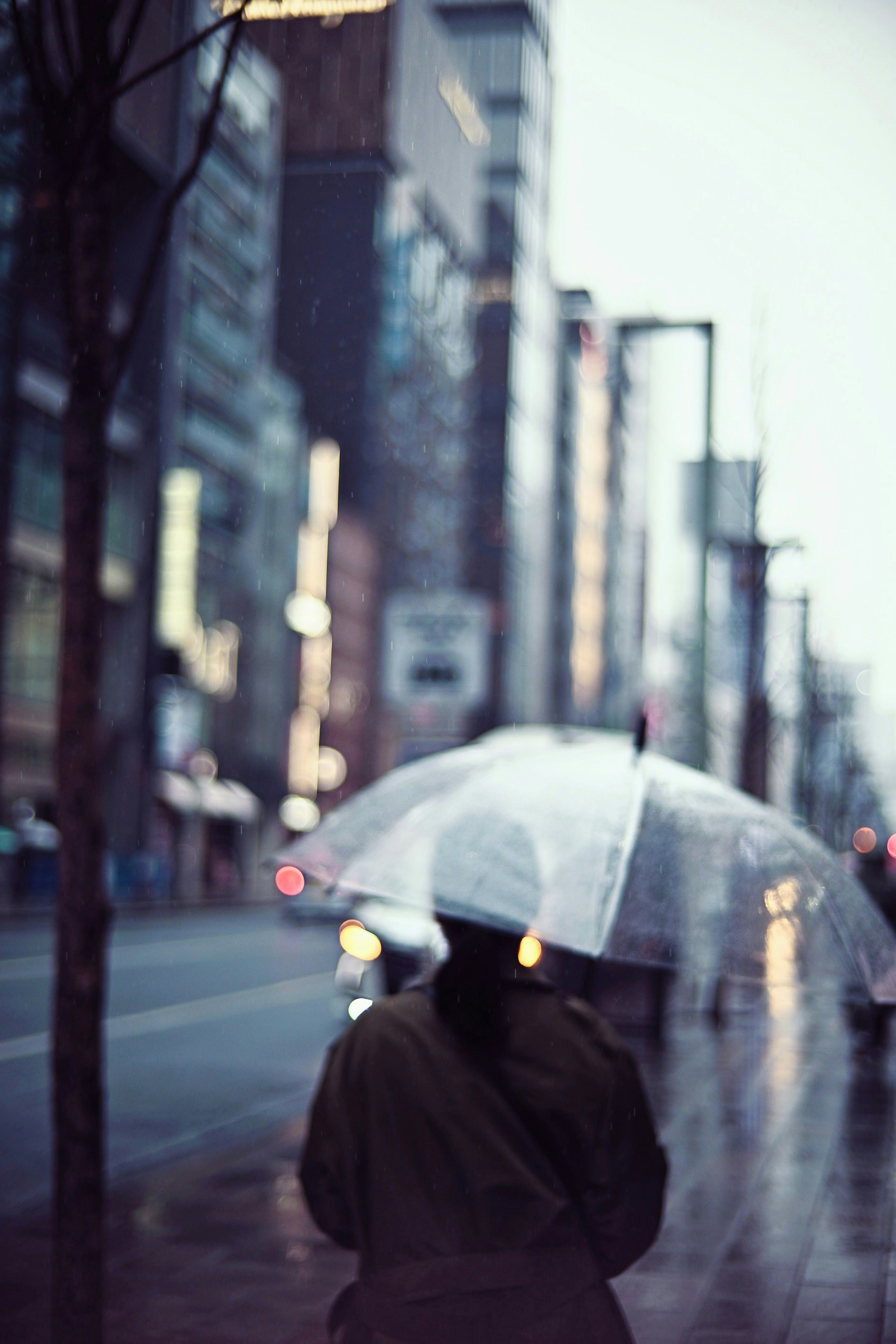 Silhouette d'une personne tenant un parapluie sous la pluie avec un décor urbain