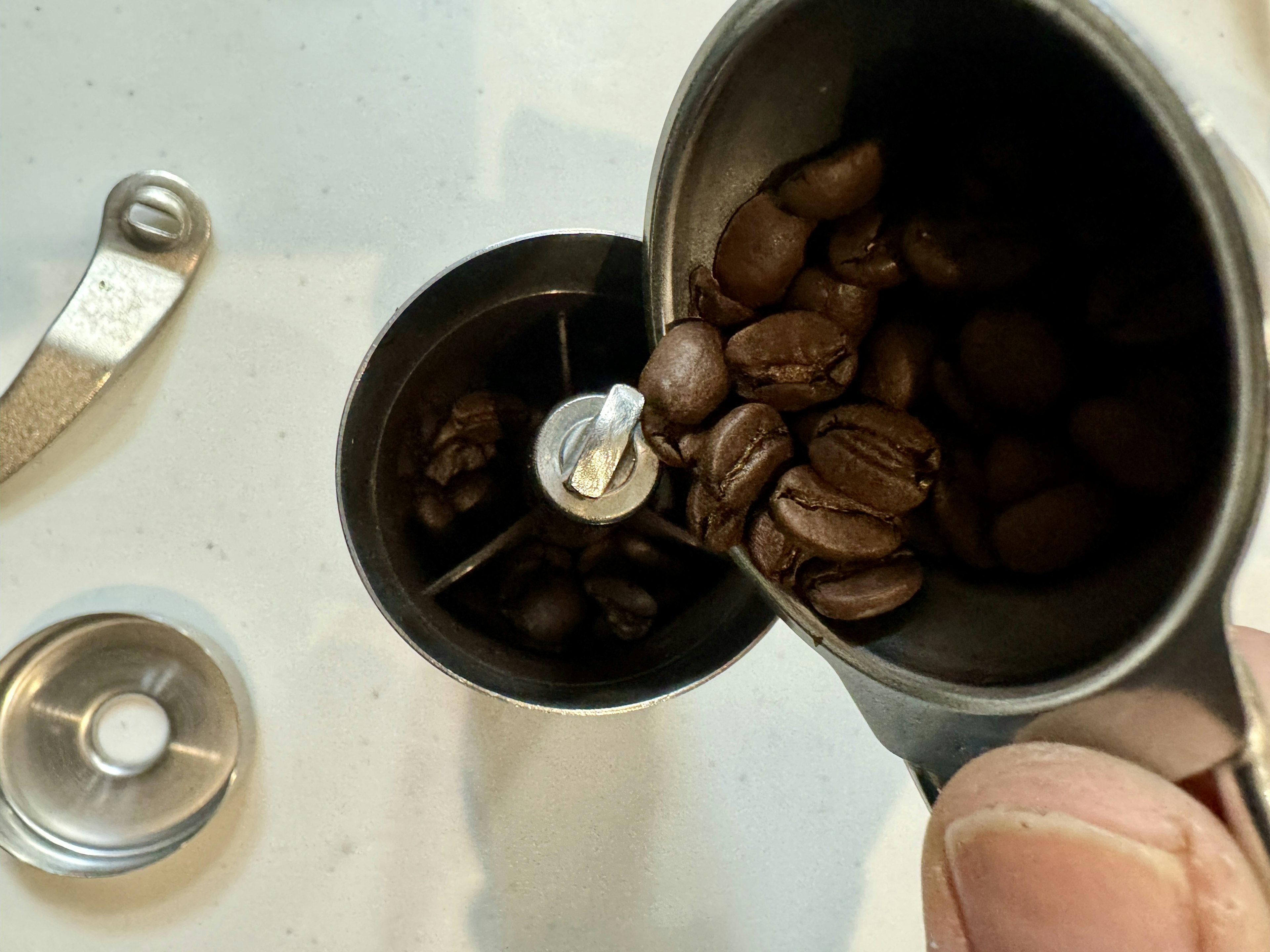 Pouring coffee beans into a grinder for grinding