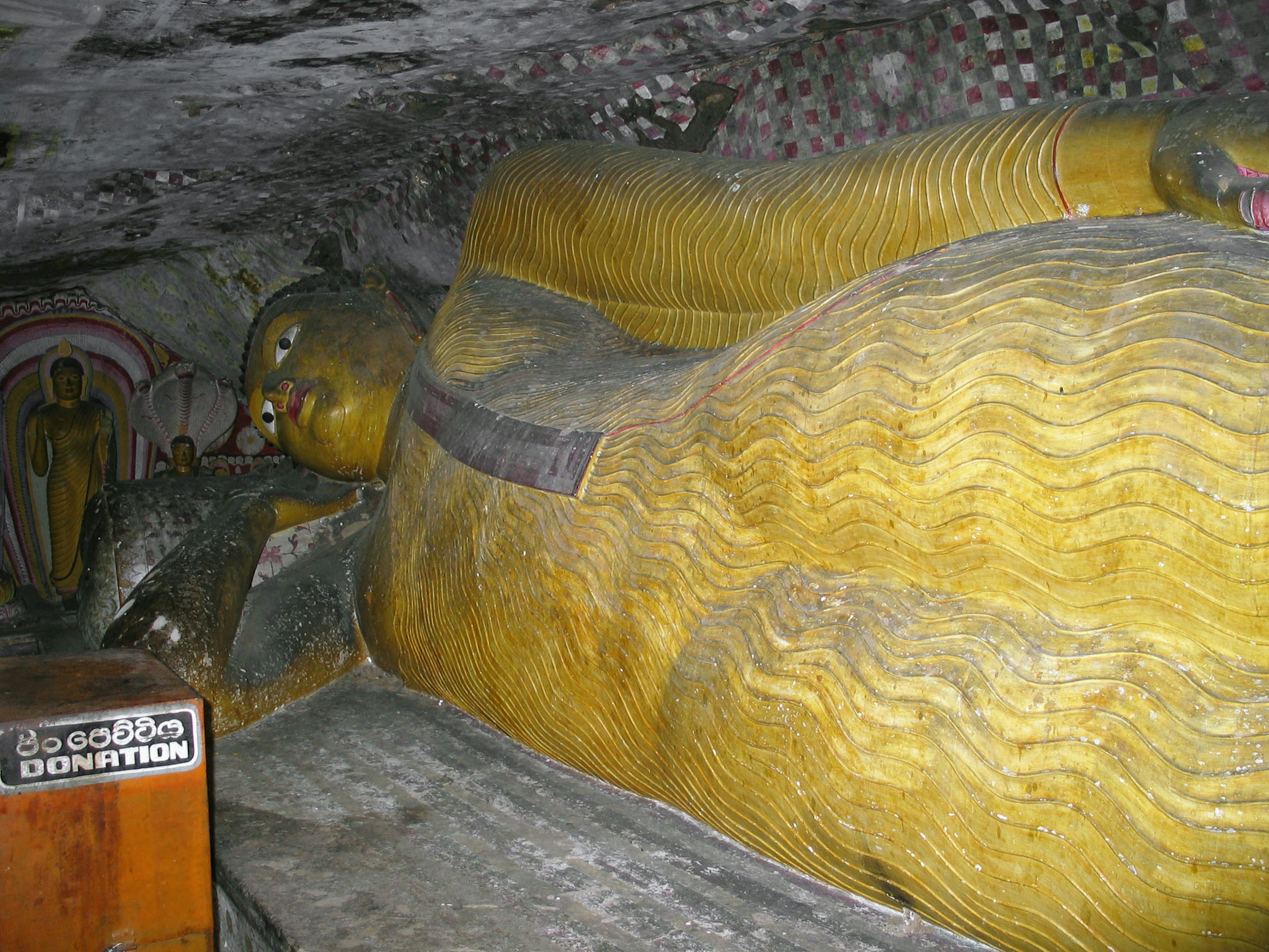 Statua del Buddha sdraiato dorato in una grotta