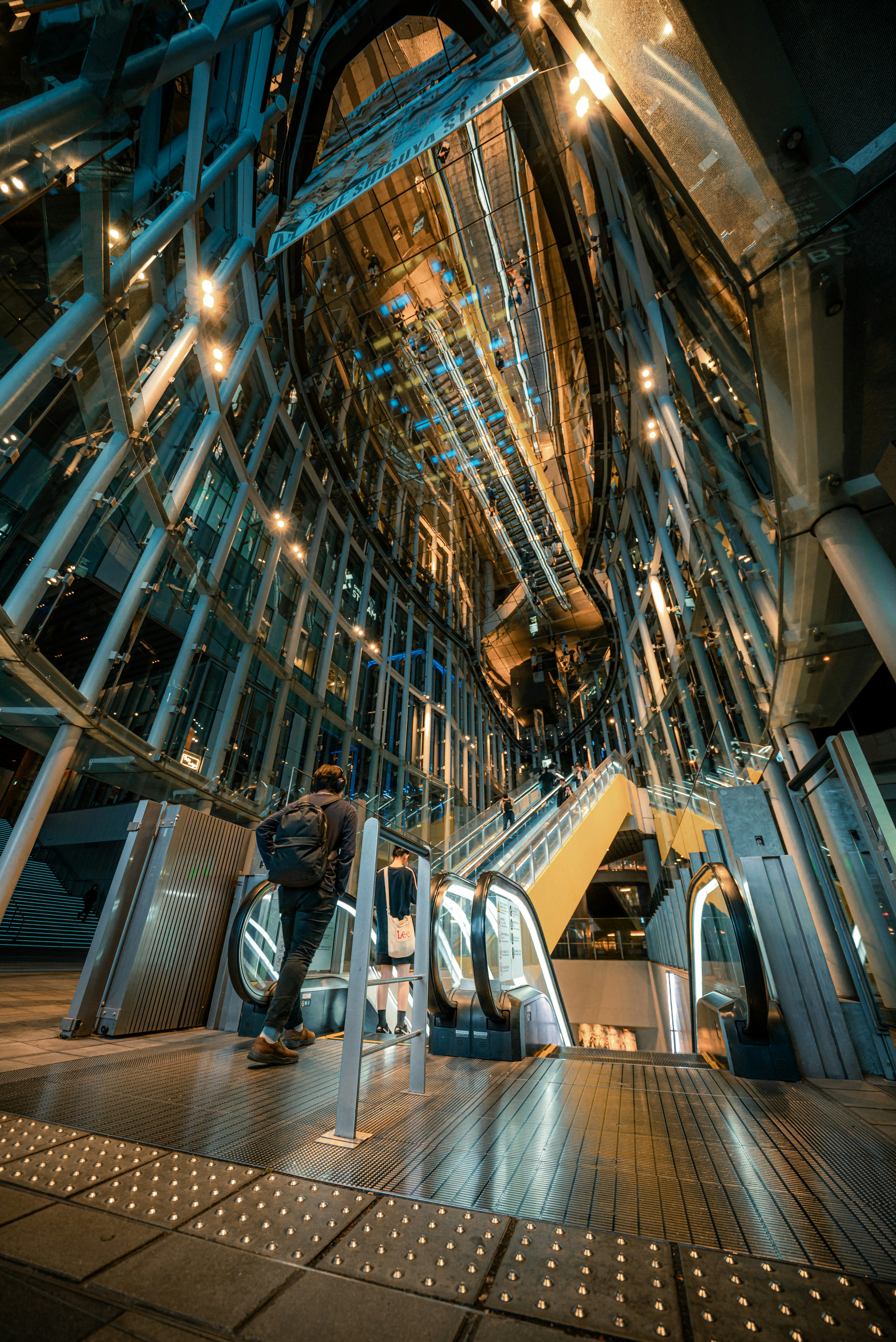 Interior de un edificio moderno con escaleras mecánicas y estructuras metálicas