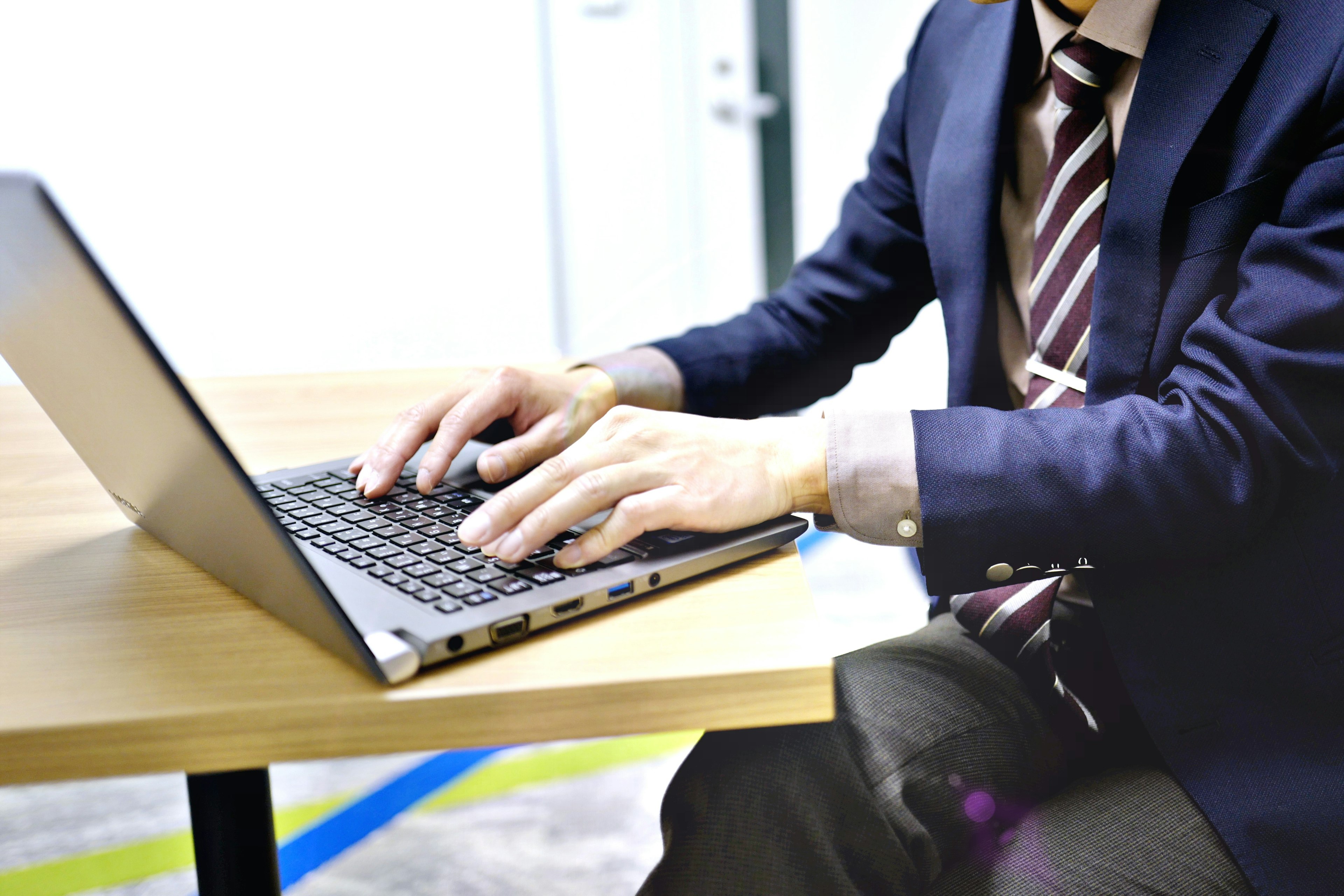 Geschäftsmann arbeitet an einem Laptop an einem Tisch