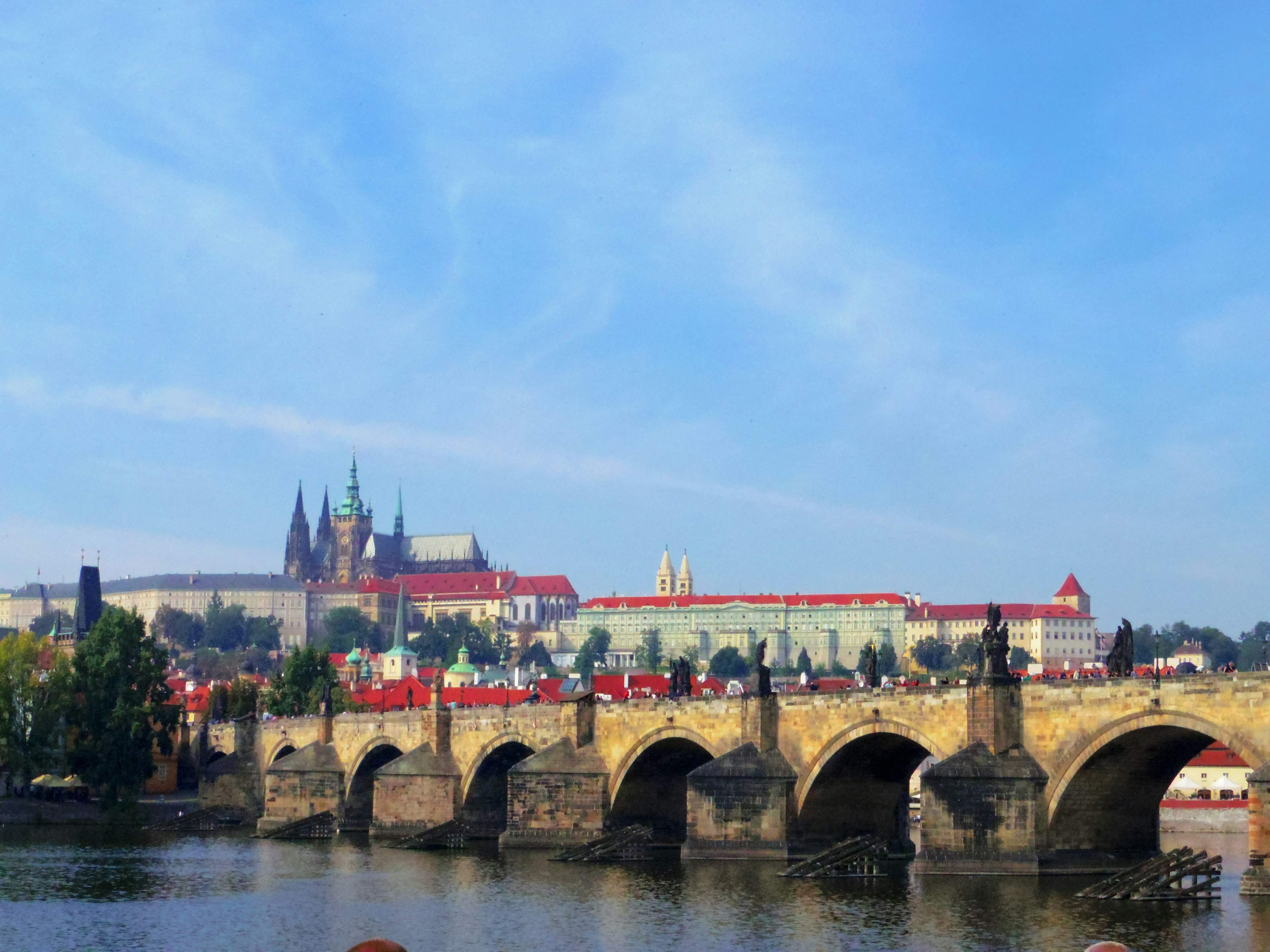 View of Charles Bridge and Prague Castle under a blue sky