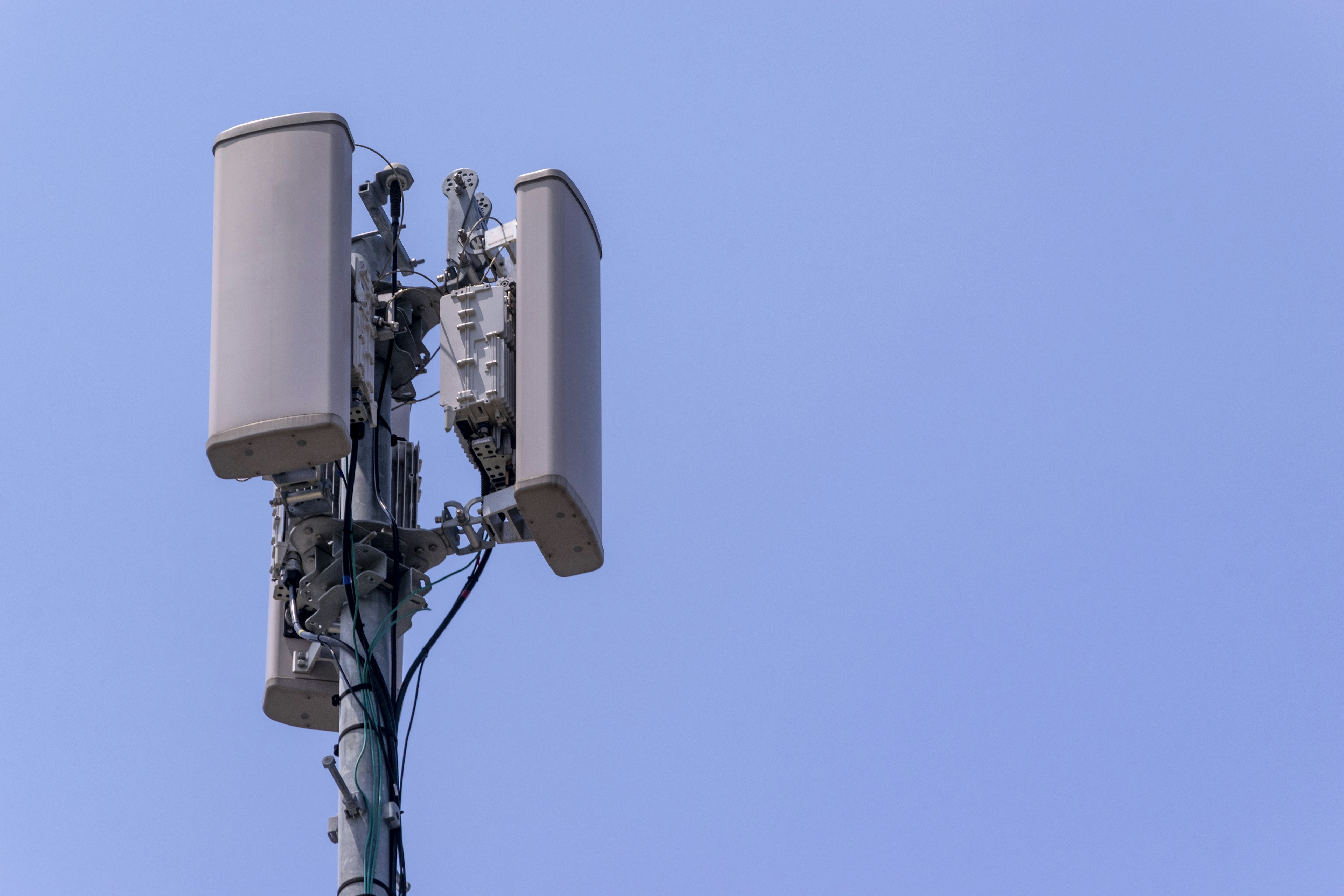 Cell phone tower antennas against a clear blue sky