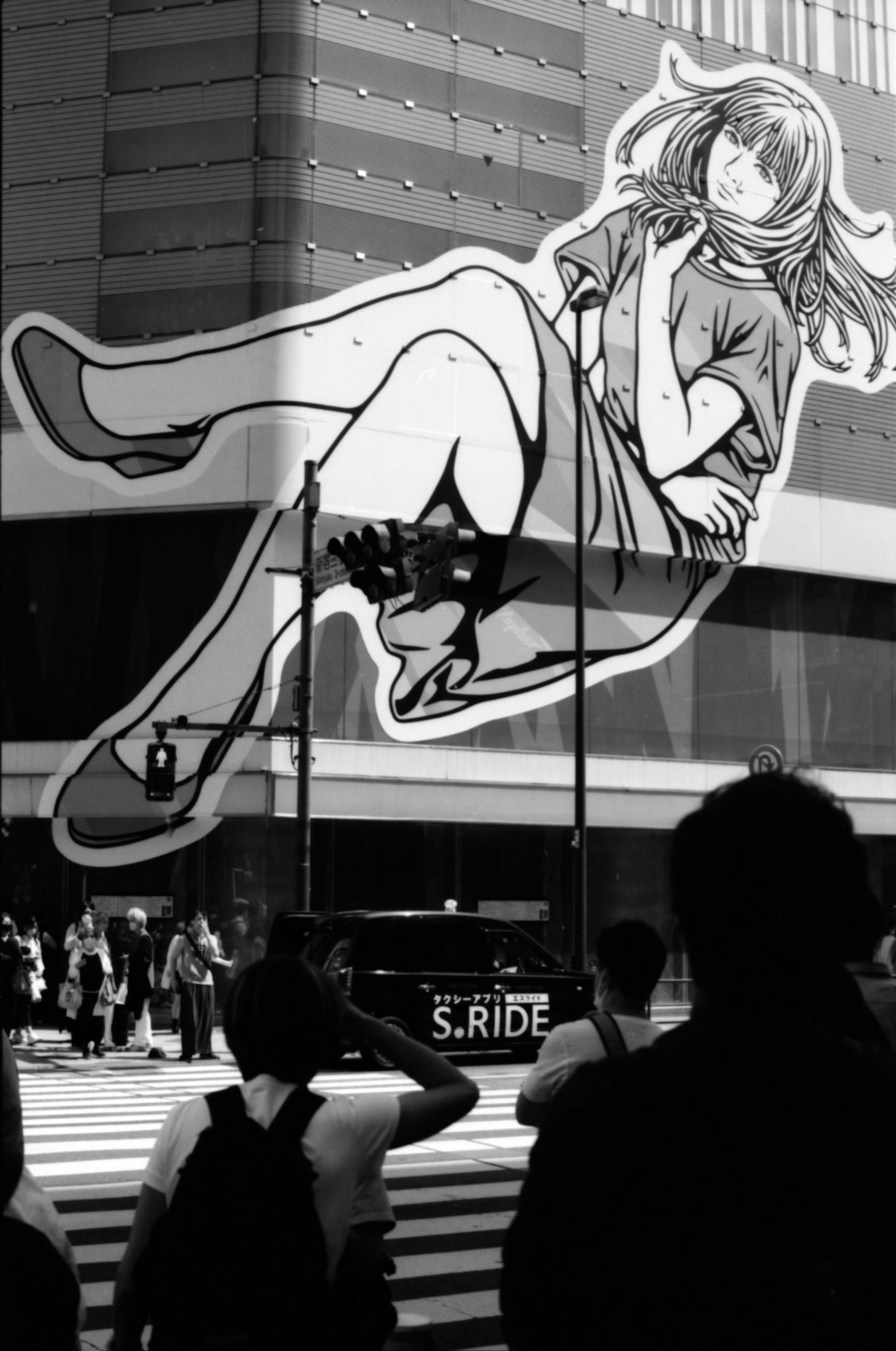 Large anime-style female character painted on a building wall in the city