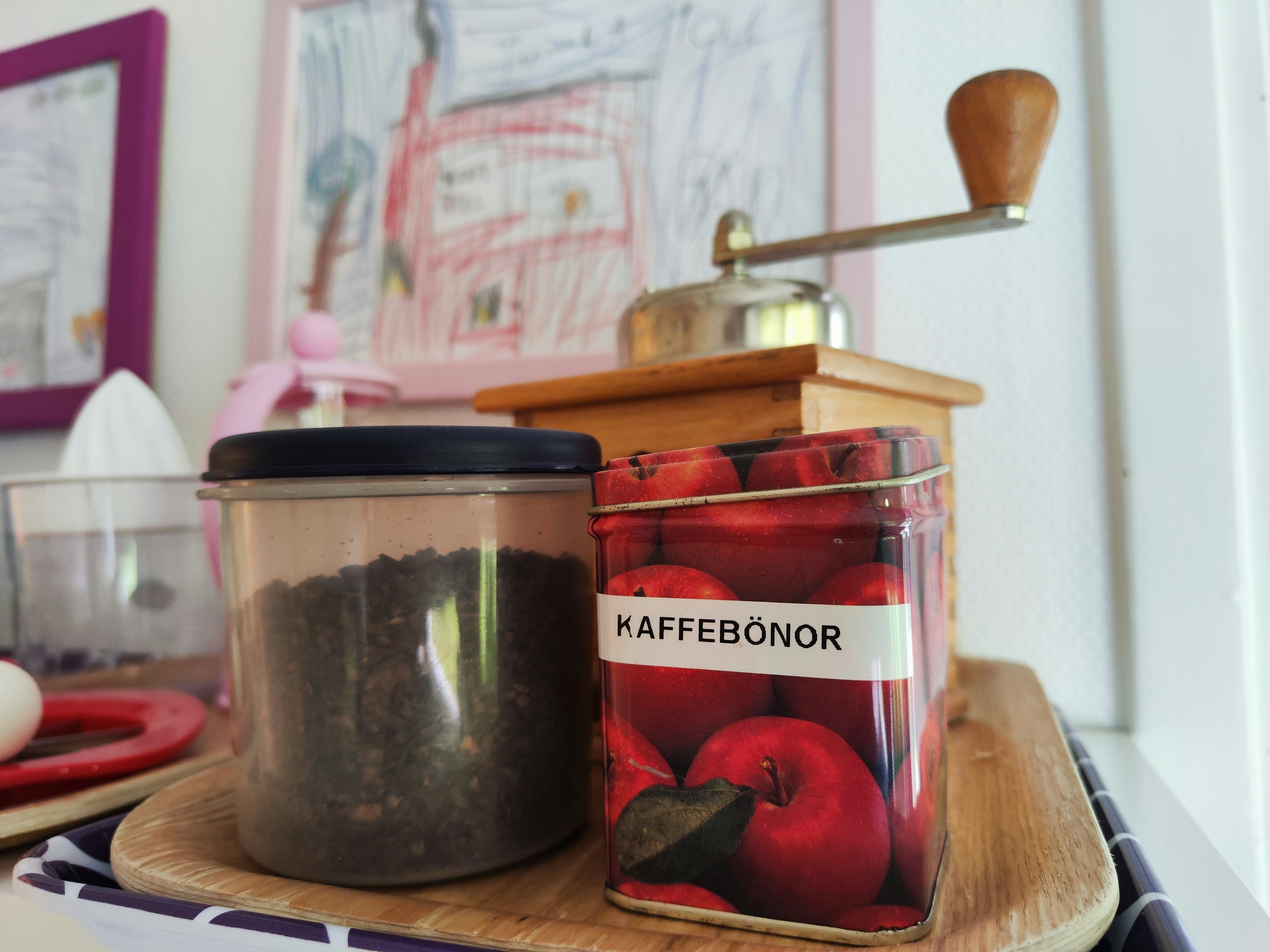 Una scena di cucina con un macinacaffè e una lattina di chicchi di caffè