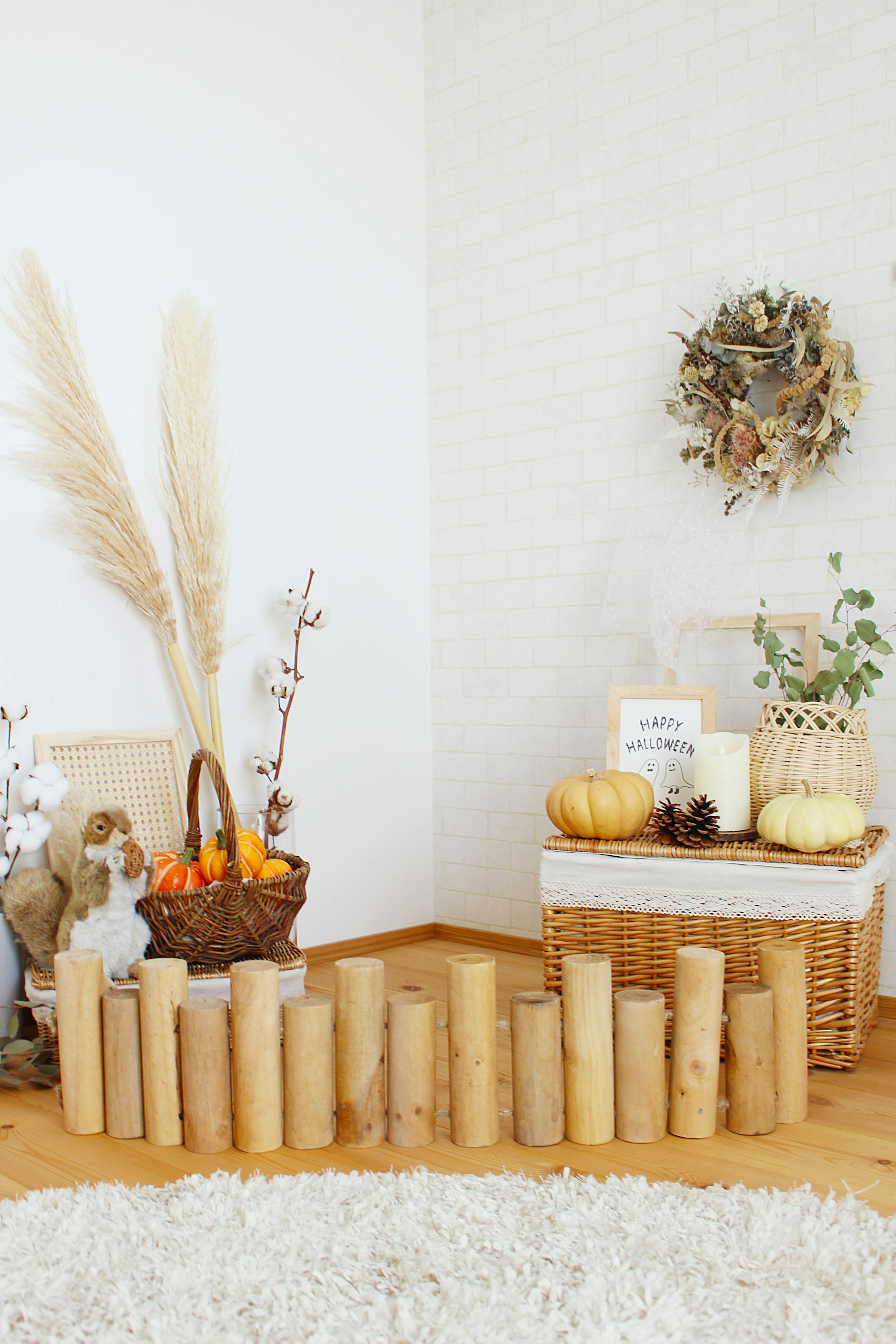 Decorative wooden cylinders arranged in a bright room featuring autumn-themed pumpkins and floral arrangements