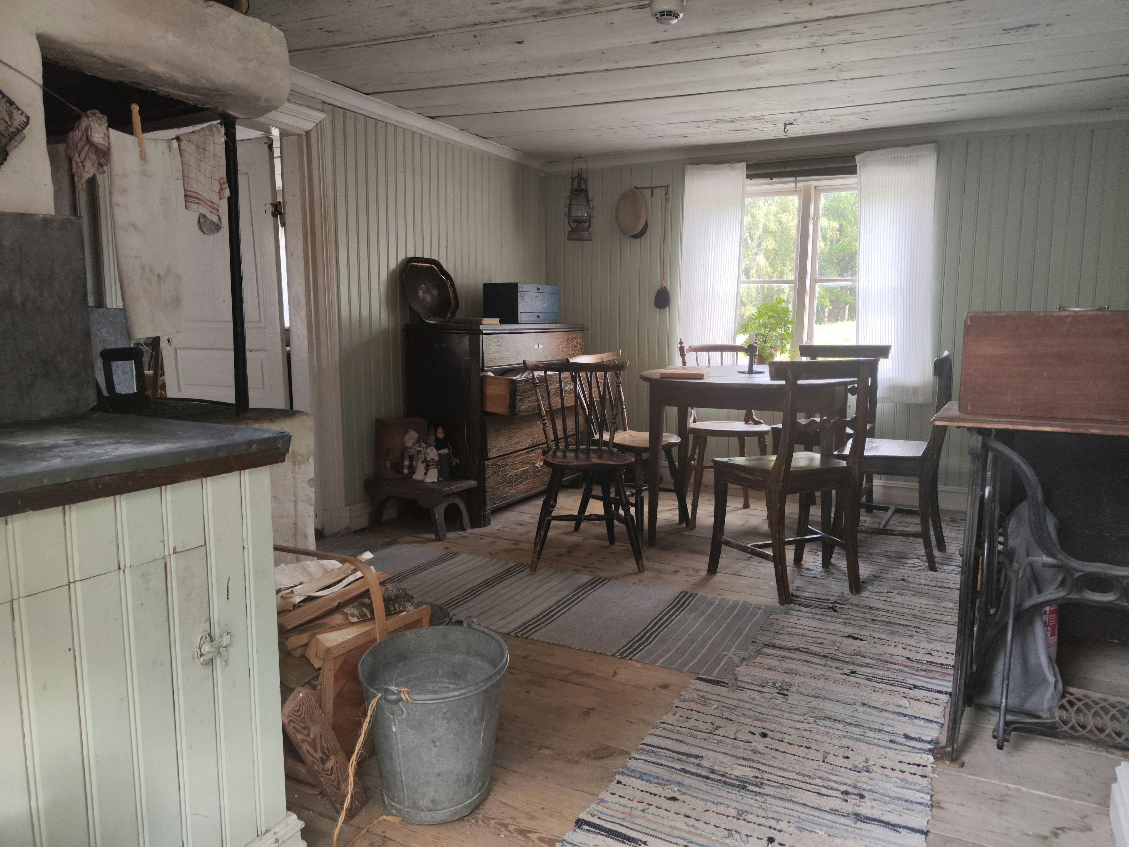 Gemütliches Esszimmer-Interieur mit Holztisch und Stühlen natürliches Licht durch die Fenster rustikale Dekoration