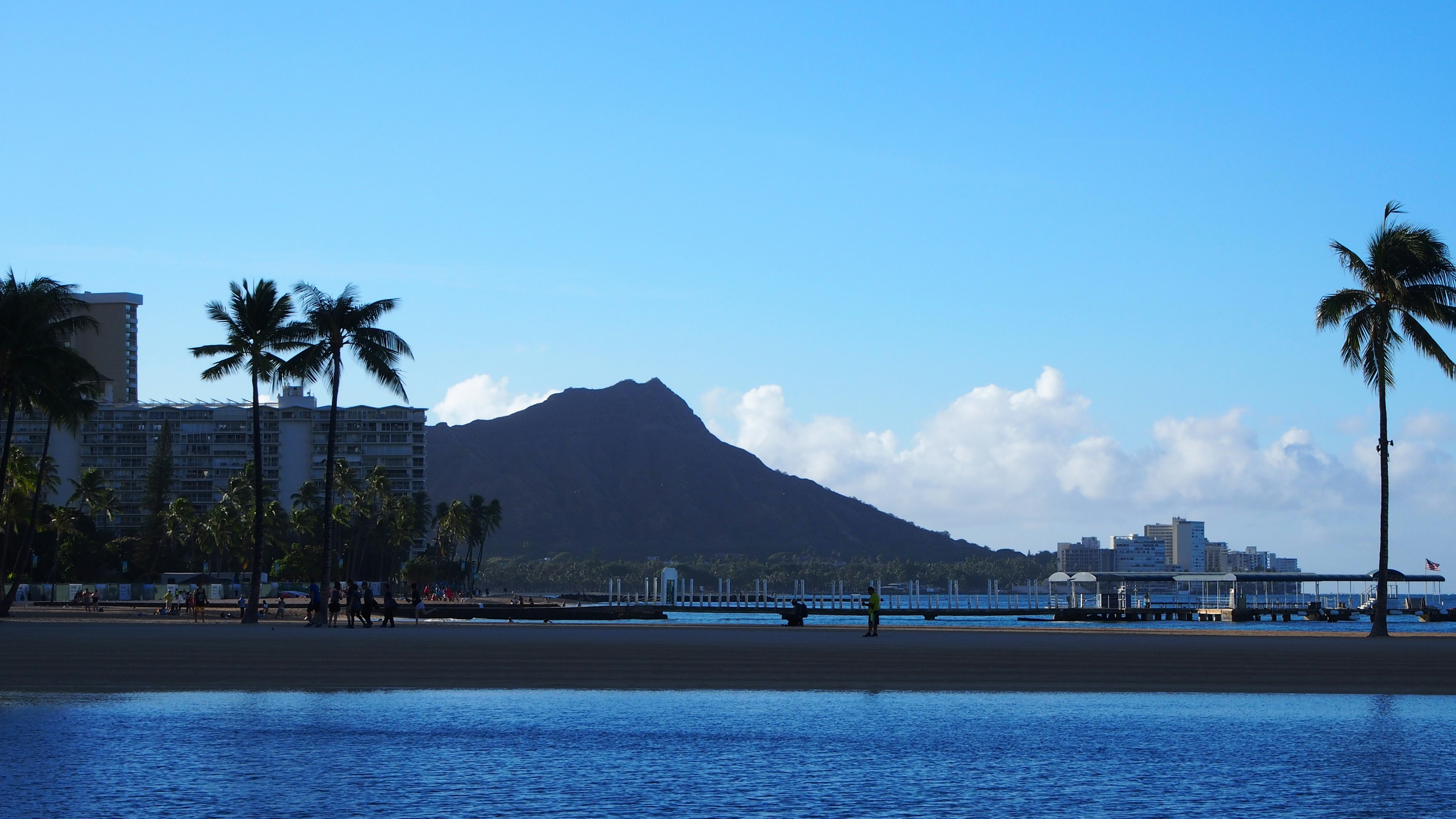 Khung cảnh tuyệt đẹp của bầu trời xanh và đại dương với Diamond Head ở phía sau bãi biển Hawaii và cây cọ