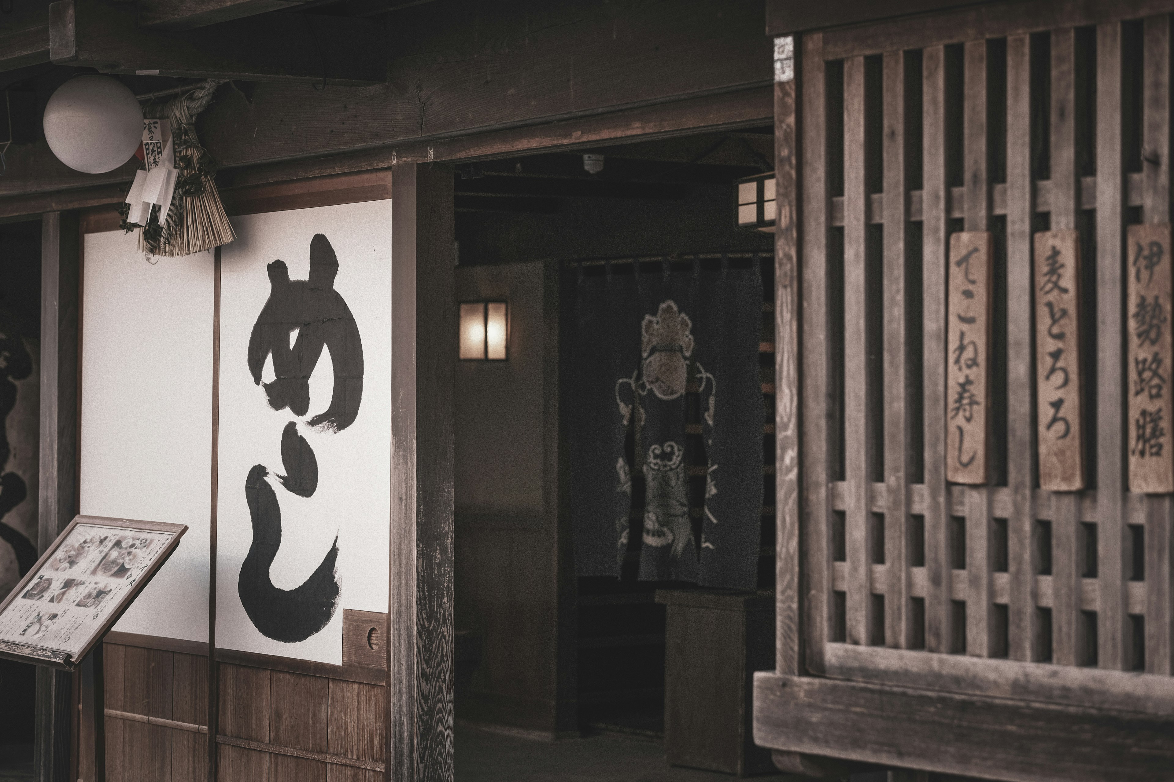 Außenansicht eines traditionellen japanischen Lokals mit großem Kanji-Schild und Holzgitter