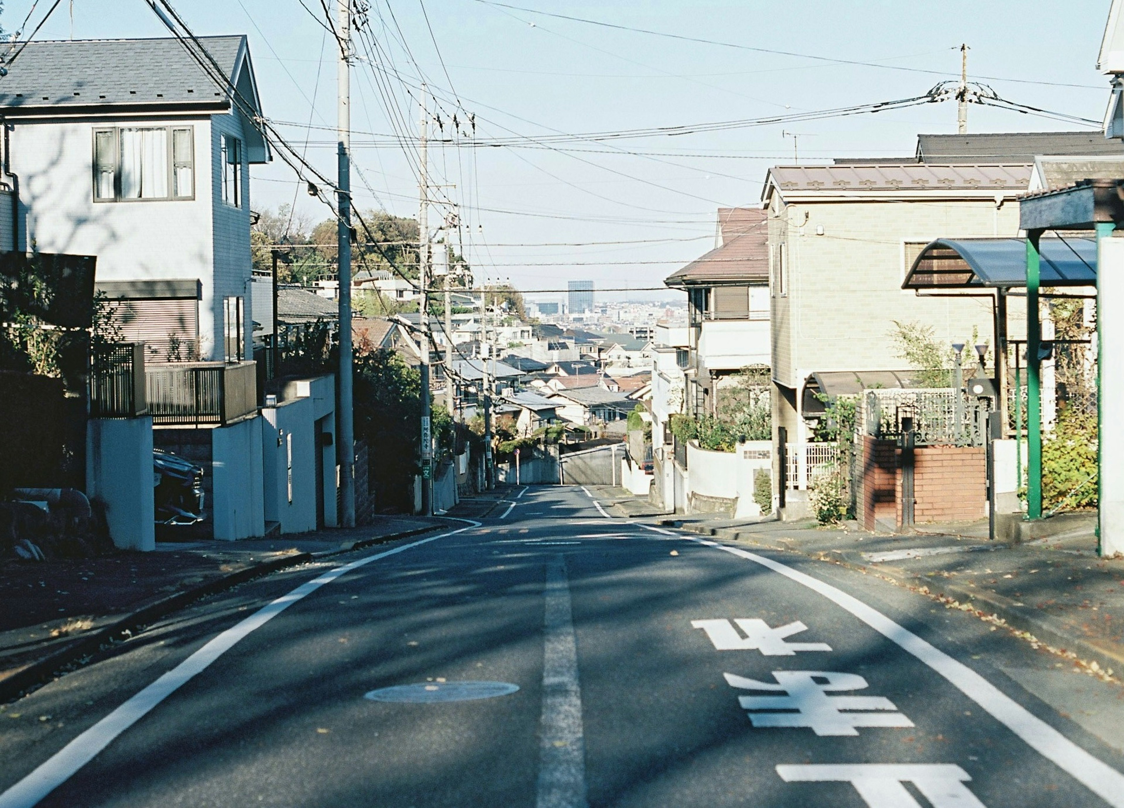 A view of a quiet residential street with a slope