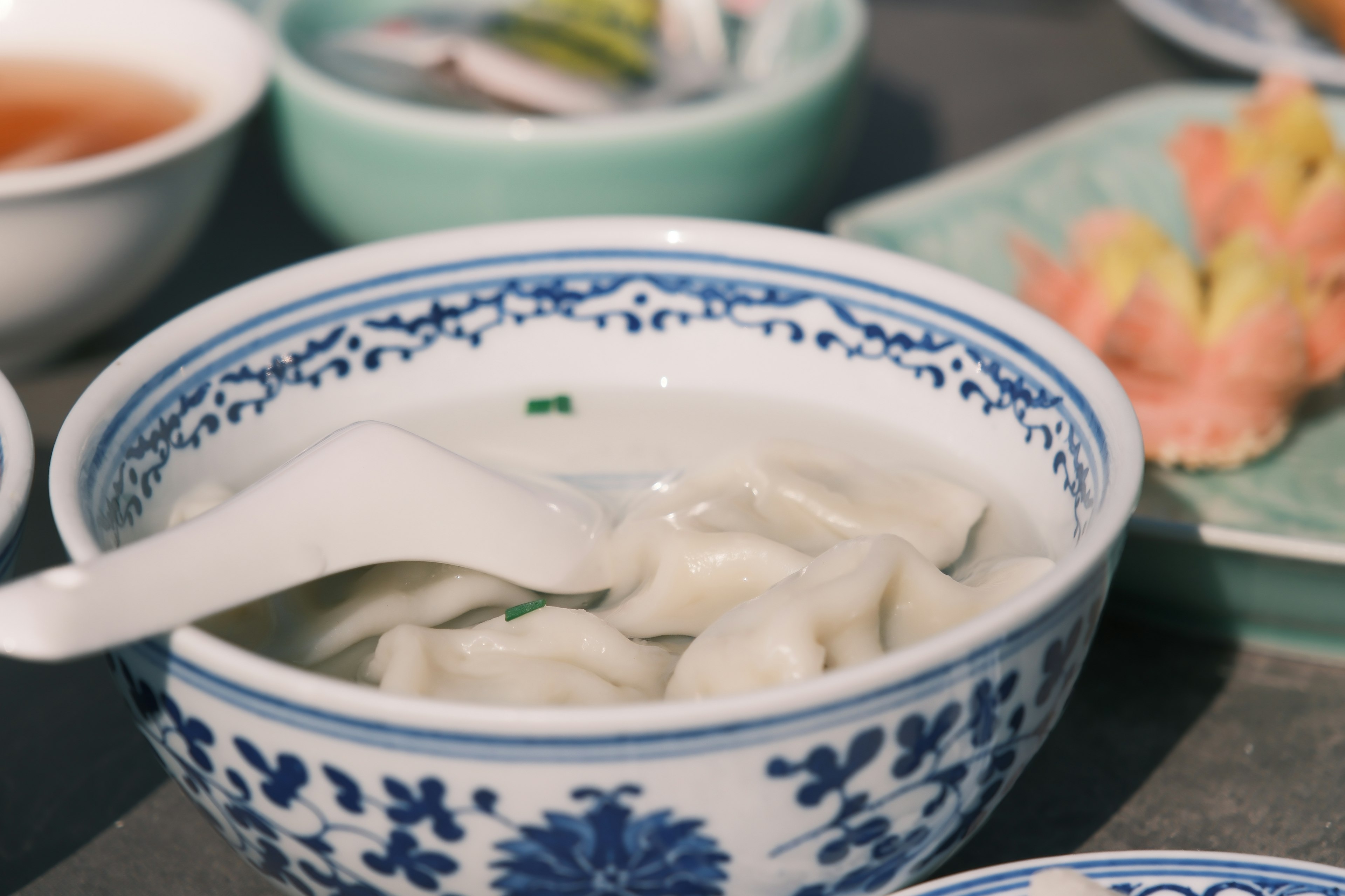 裝有白色湯的餃子碗，帶有藍色花卉圖案