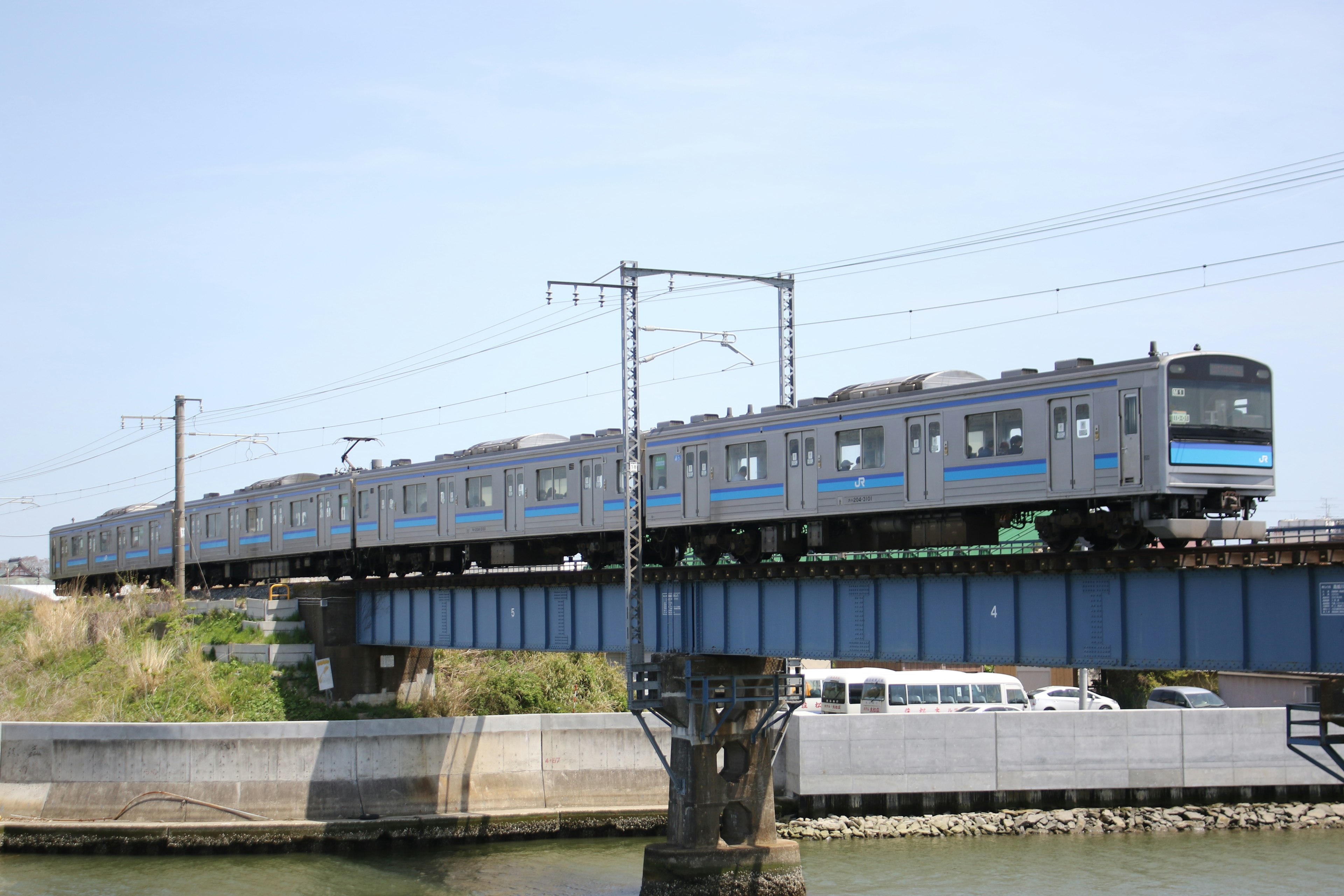 Treno blu che attraversa un ponte sopra il fiume