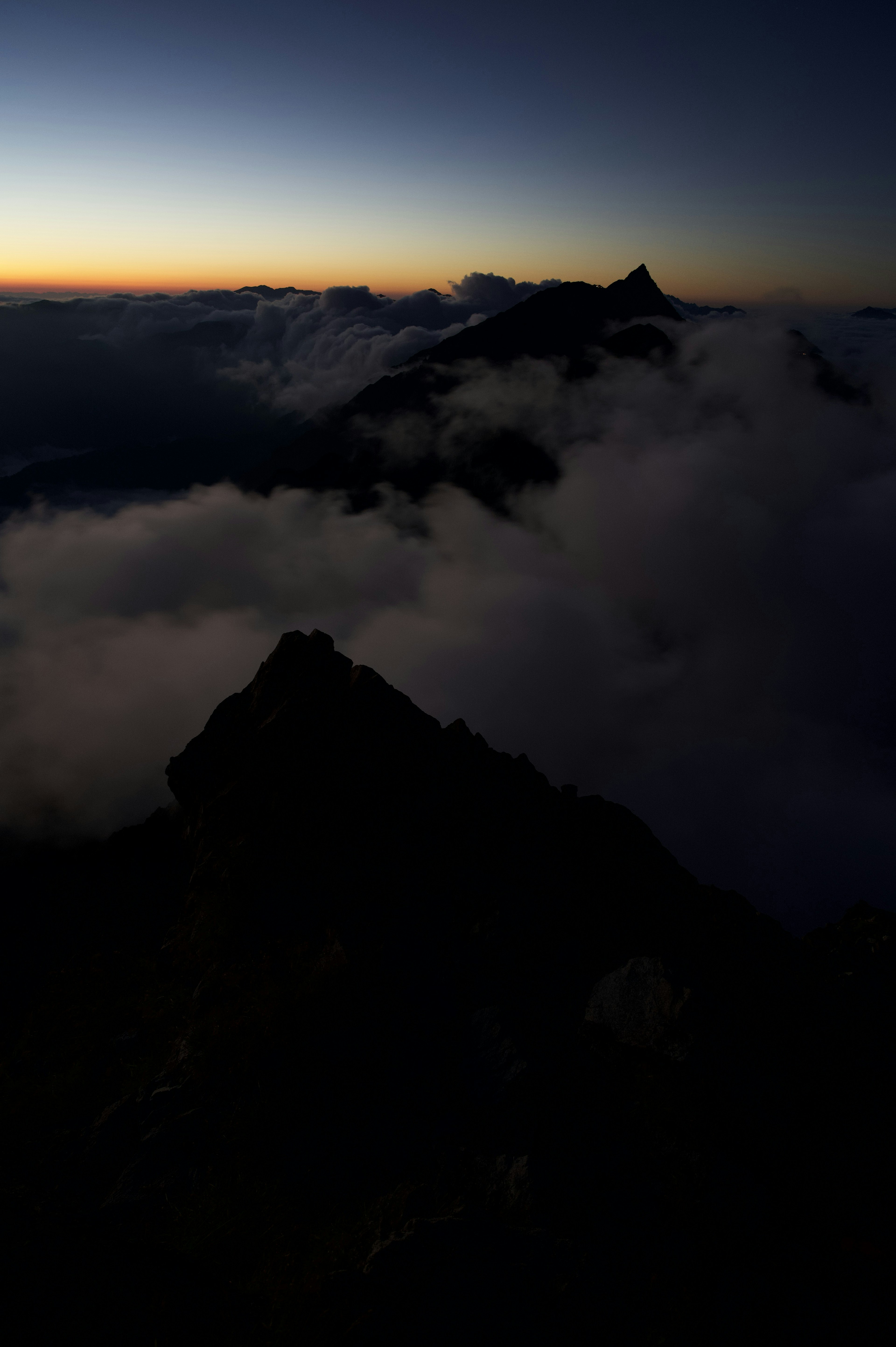 Silhouette di montagne con nuvole all'alba