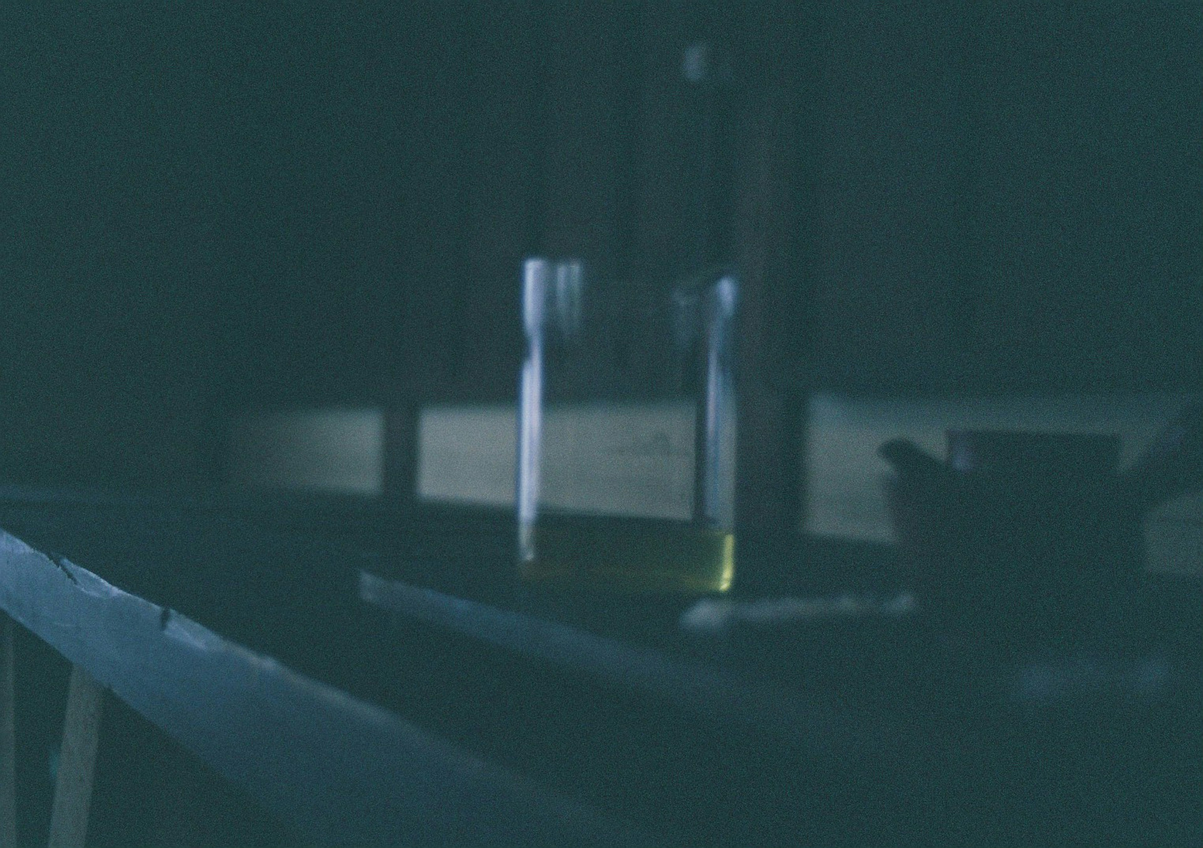 Table with a transparent bottle and tea set in a dark setting