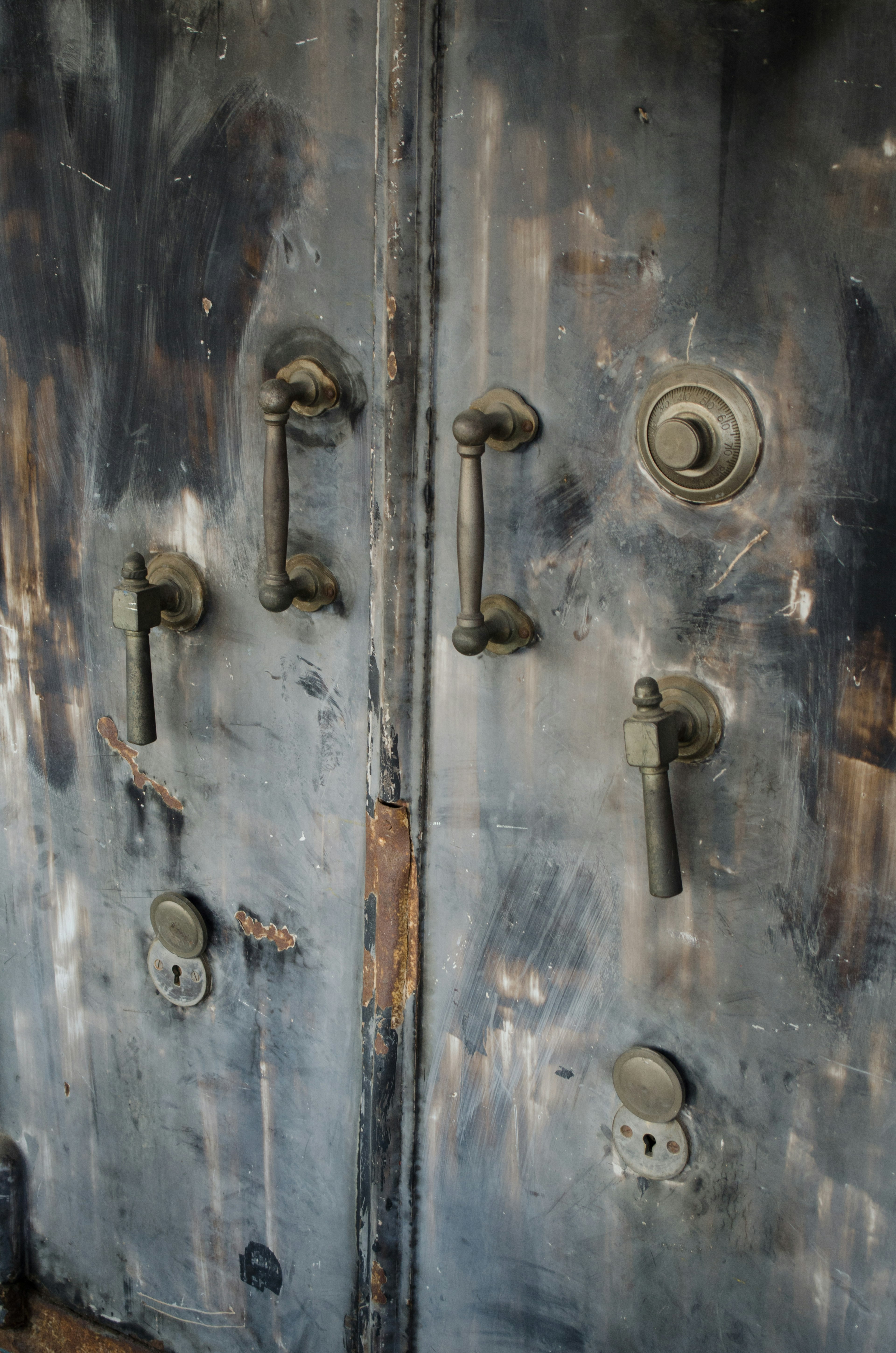 Imagen que presenta manijas de metal montadas en una puerta de madera antigua