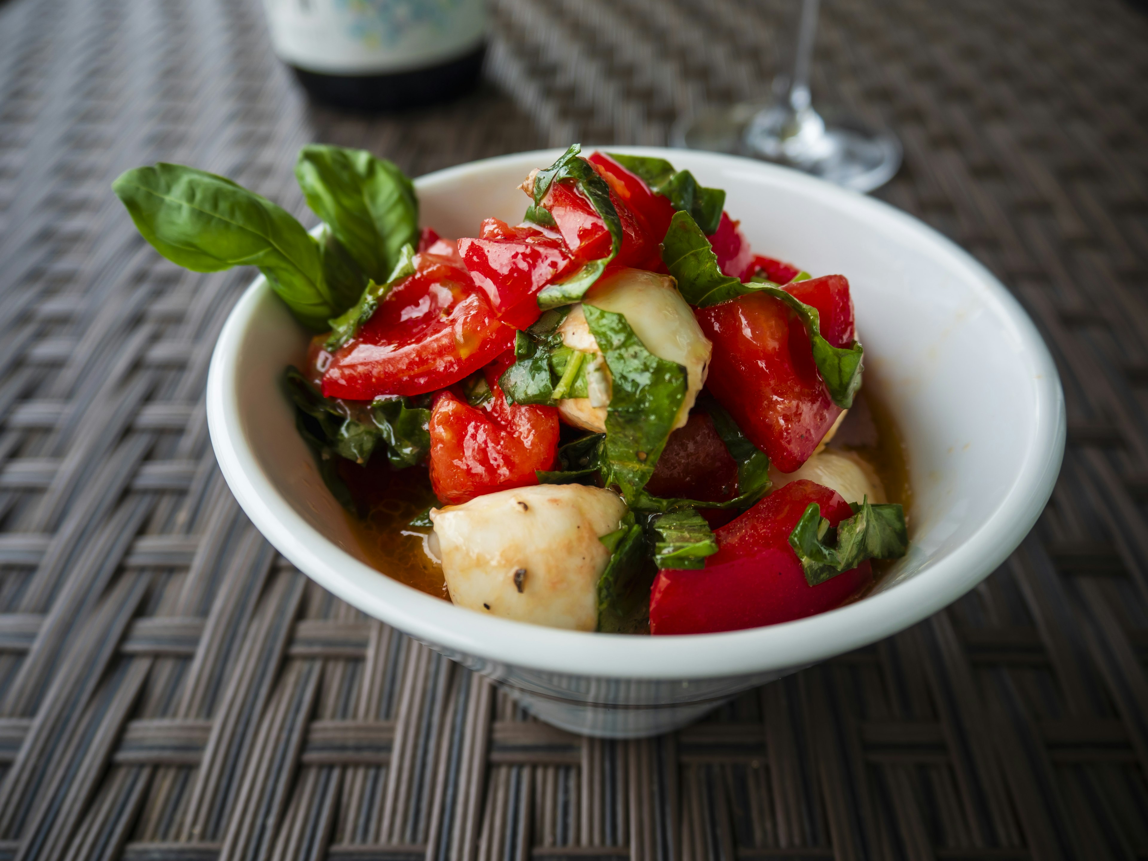 Insalata di pomodori freschi e basilico servita in una ciotola bianca