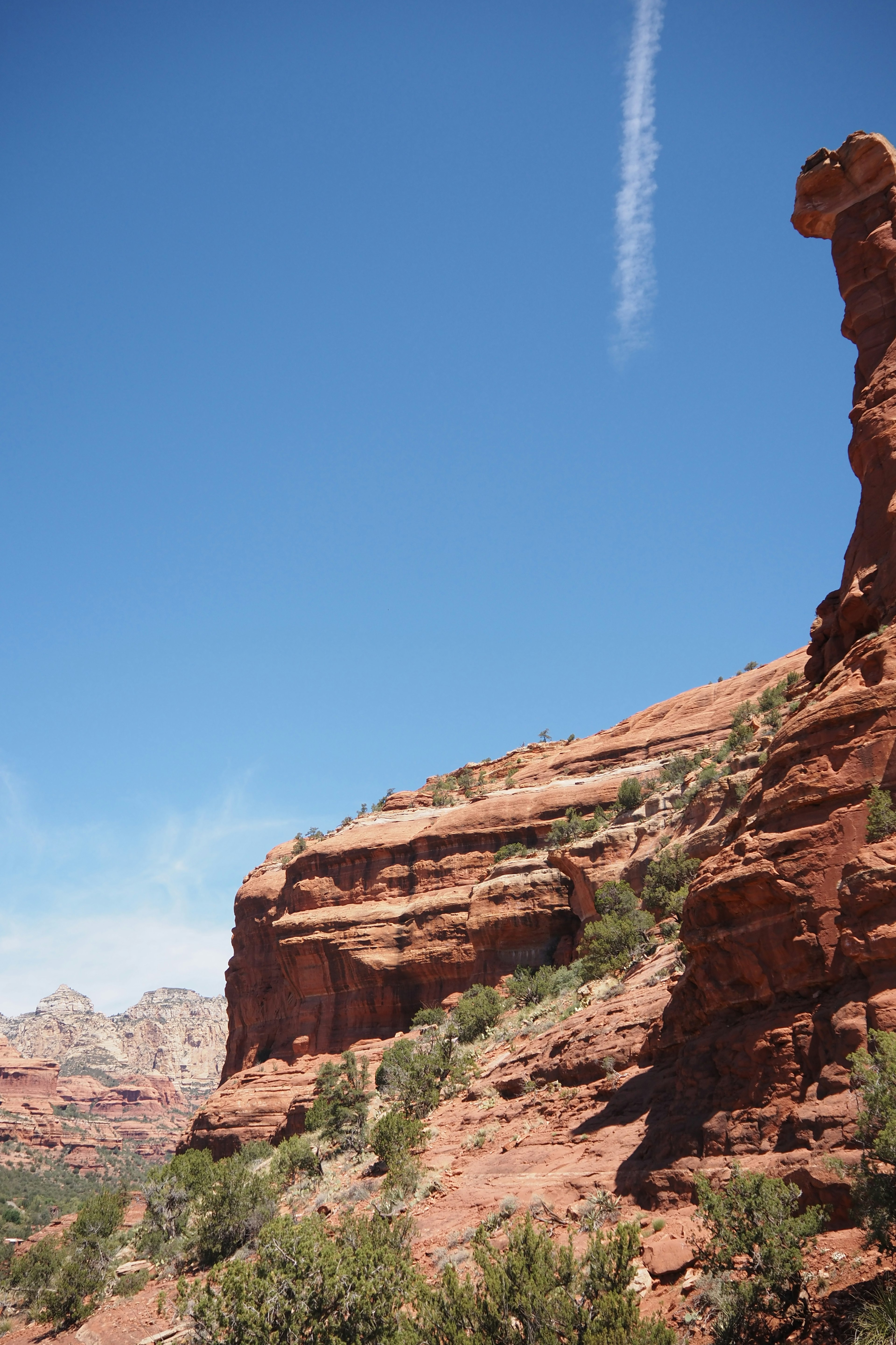 Paysage naturel avec des formations rocheuses rouges et une végétation verte sous un ciel bleu