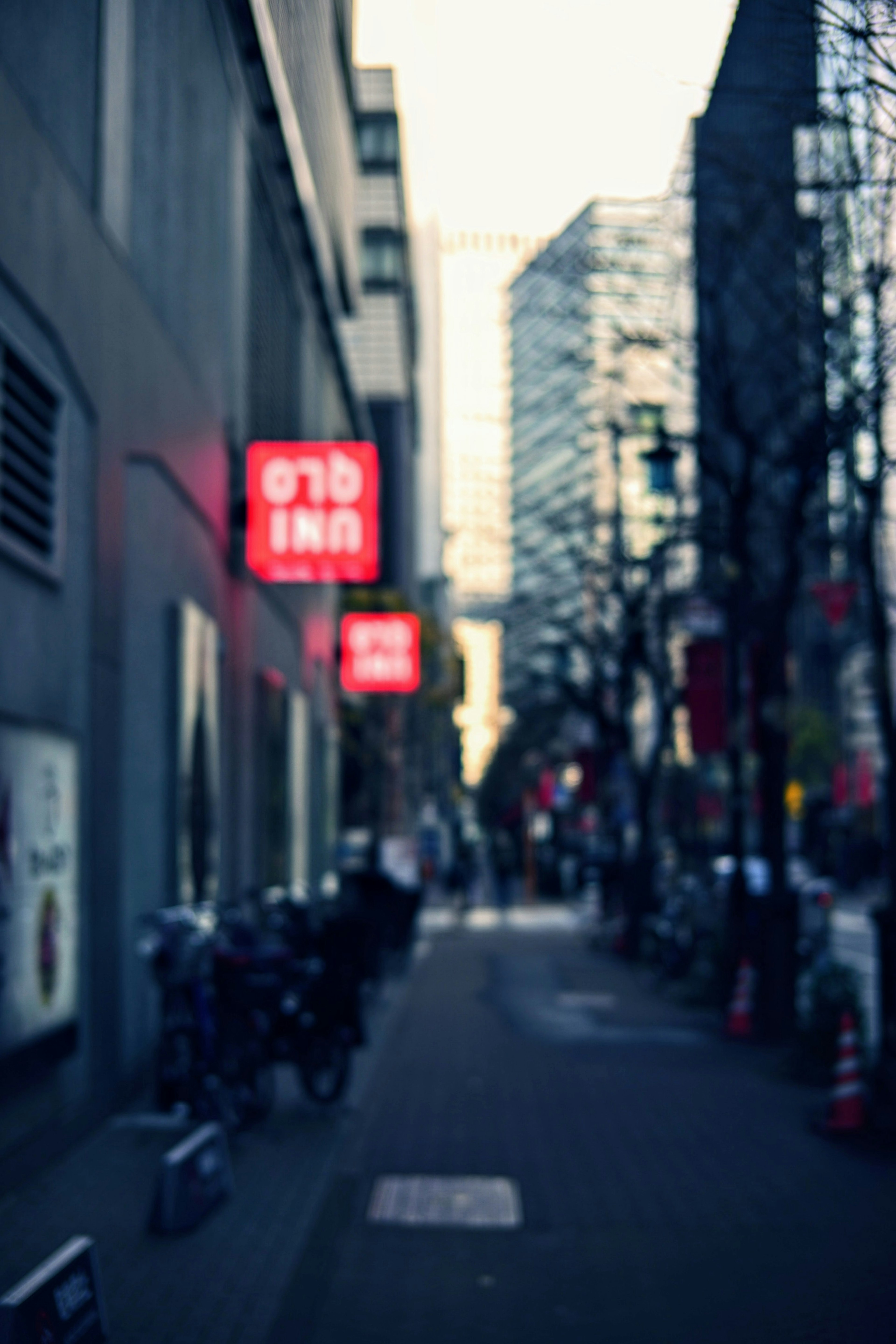 Blurred city street featuring a red sign for a lodging facility