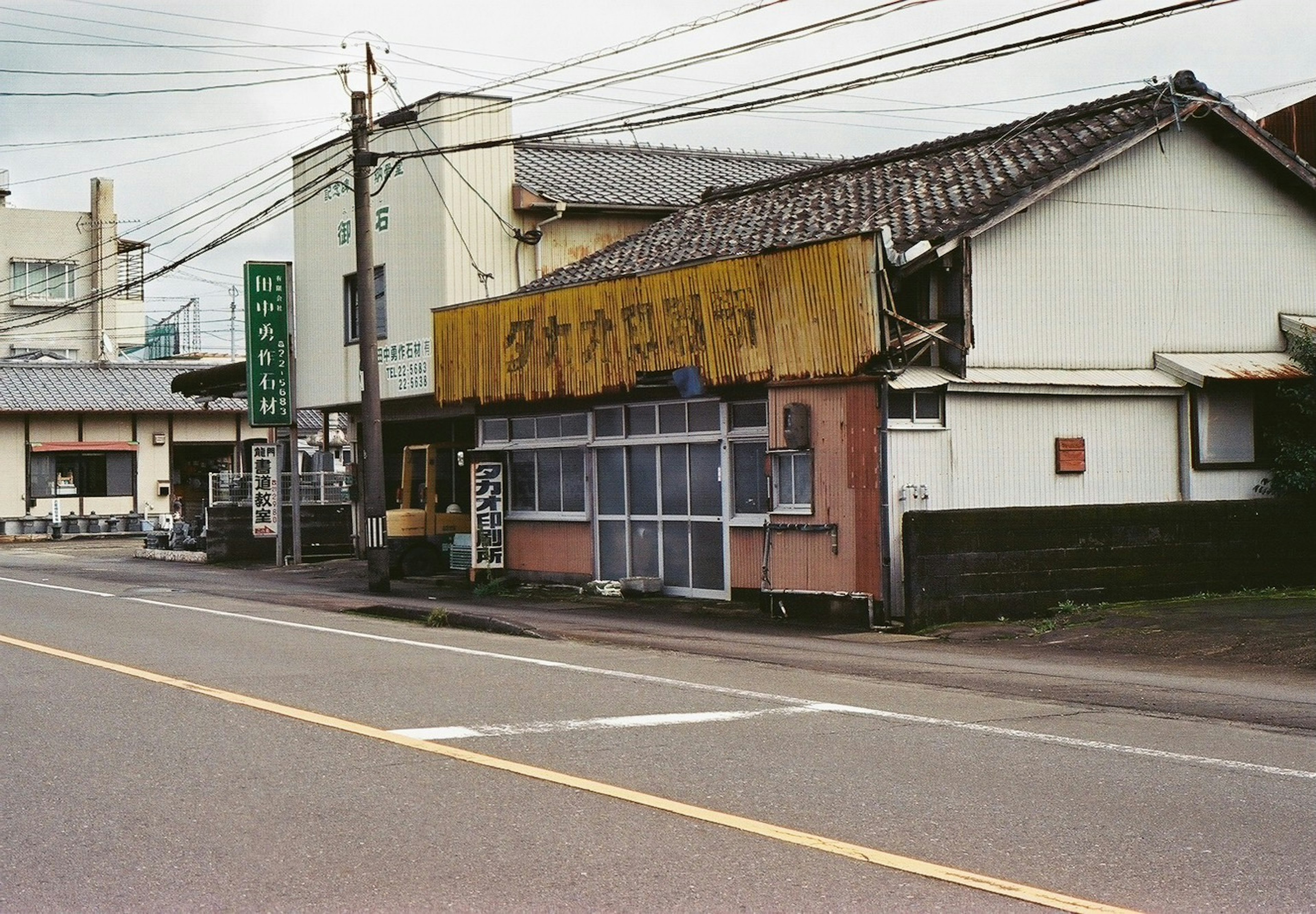 Scène d'une rue de magasins japonais anciens avec une maison à toit de tuiles et une signalisation marquante