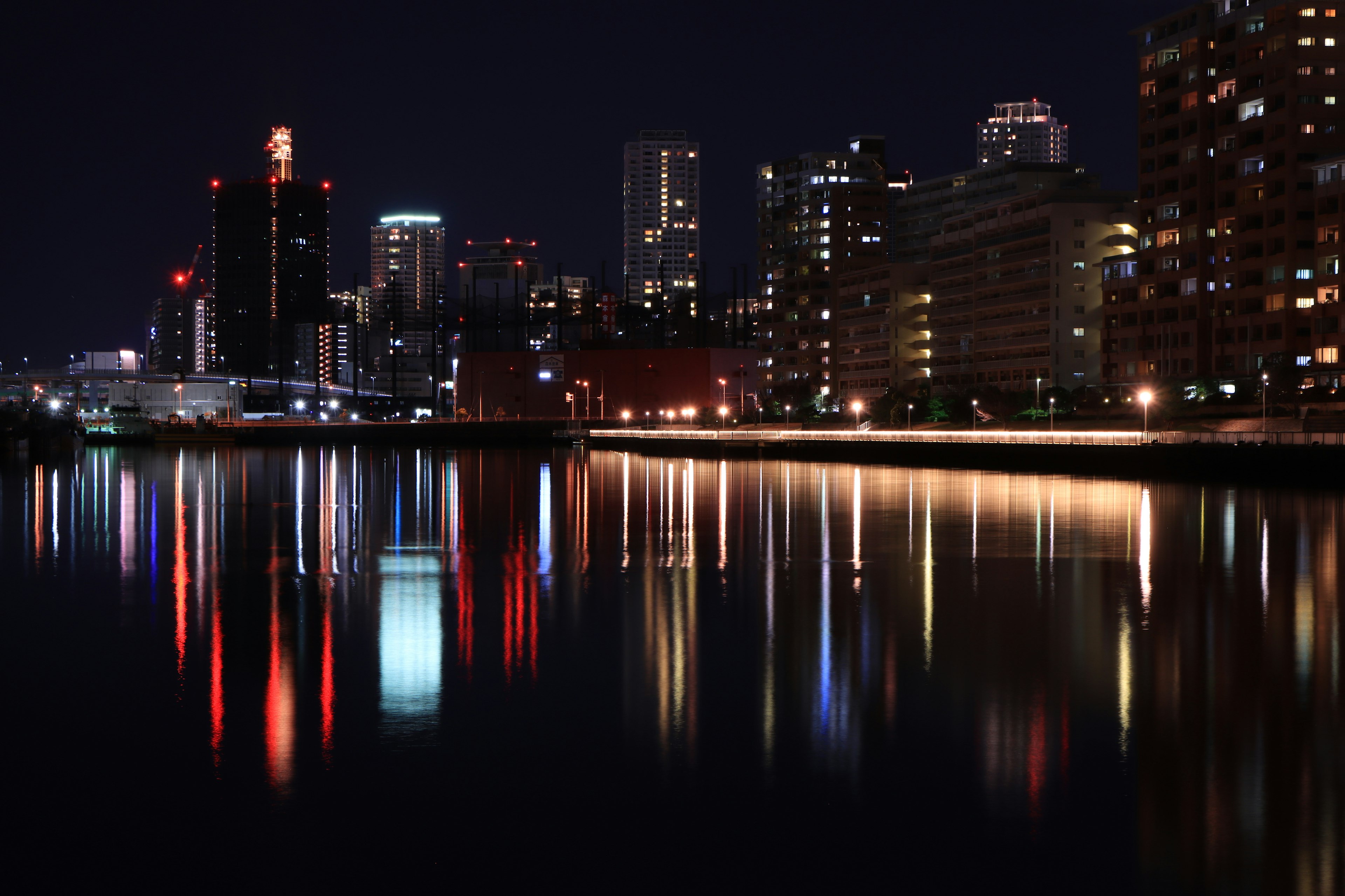 Reflejos brillantes de edificios en la superficie del agua por la noche