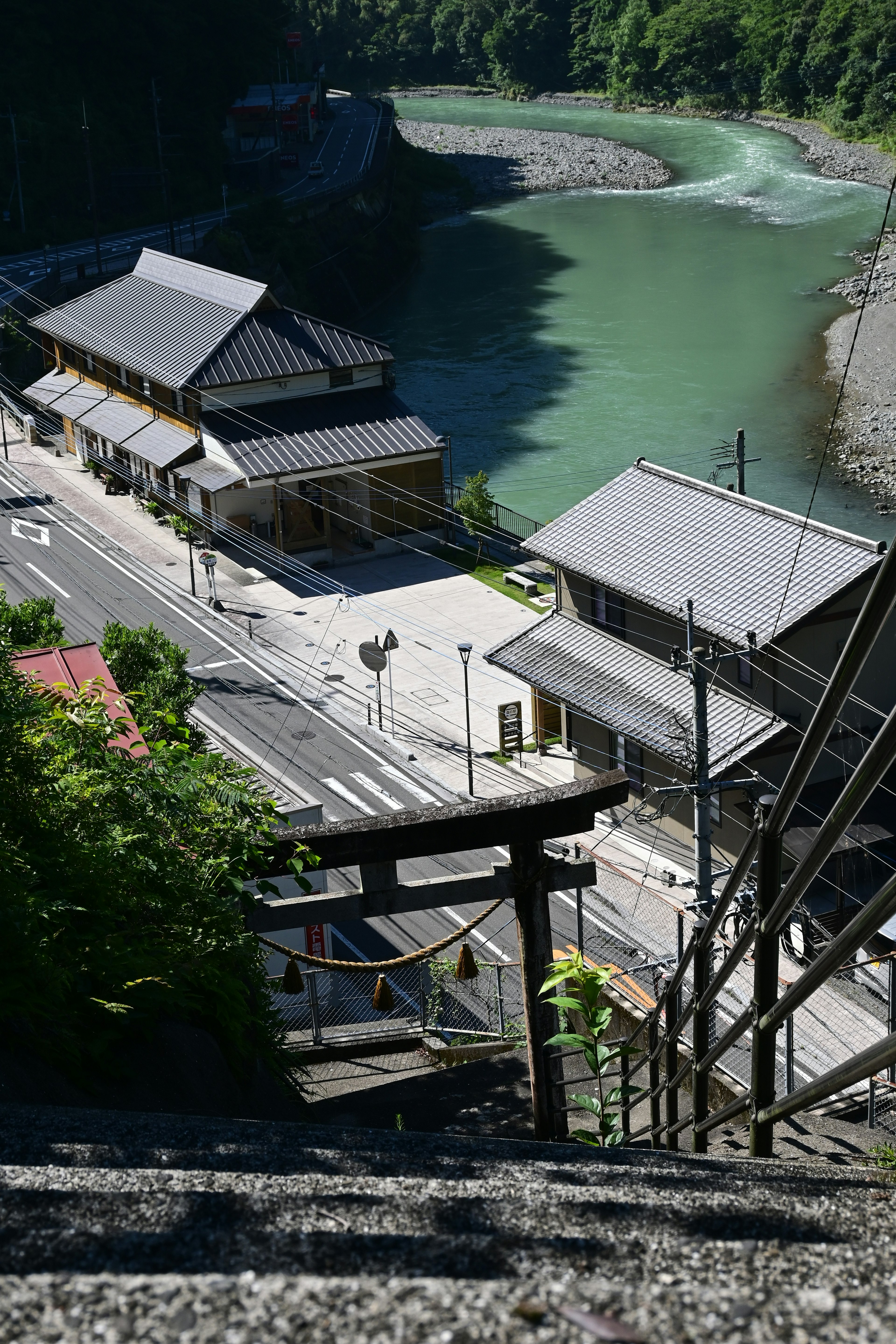 Scenic view of traditional Japanese buildings near a river with a torii gate