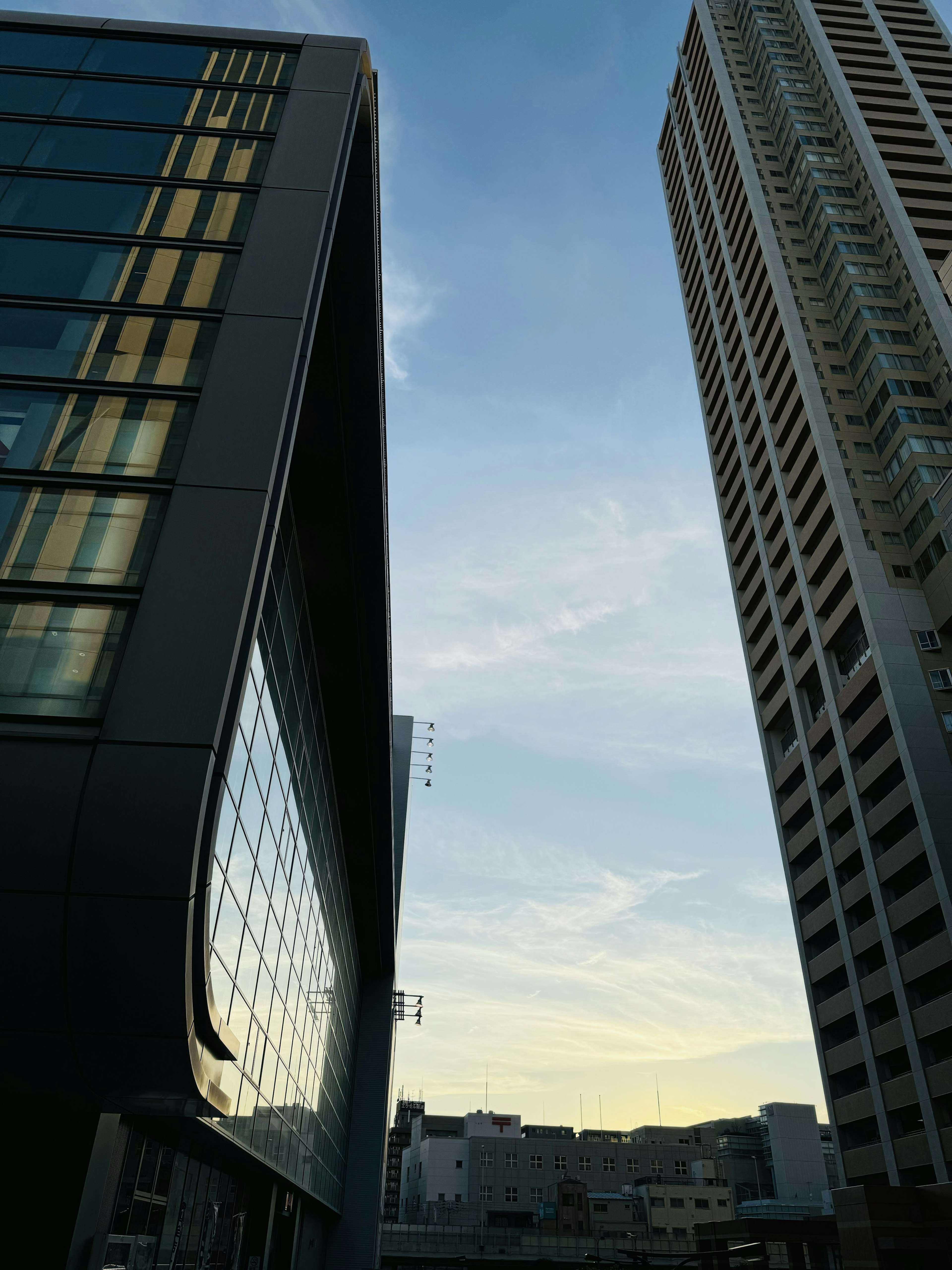 Sky and clouds visible between tall buildings