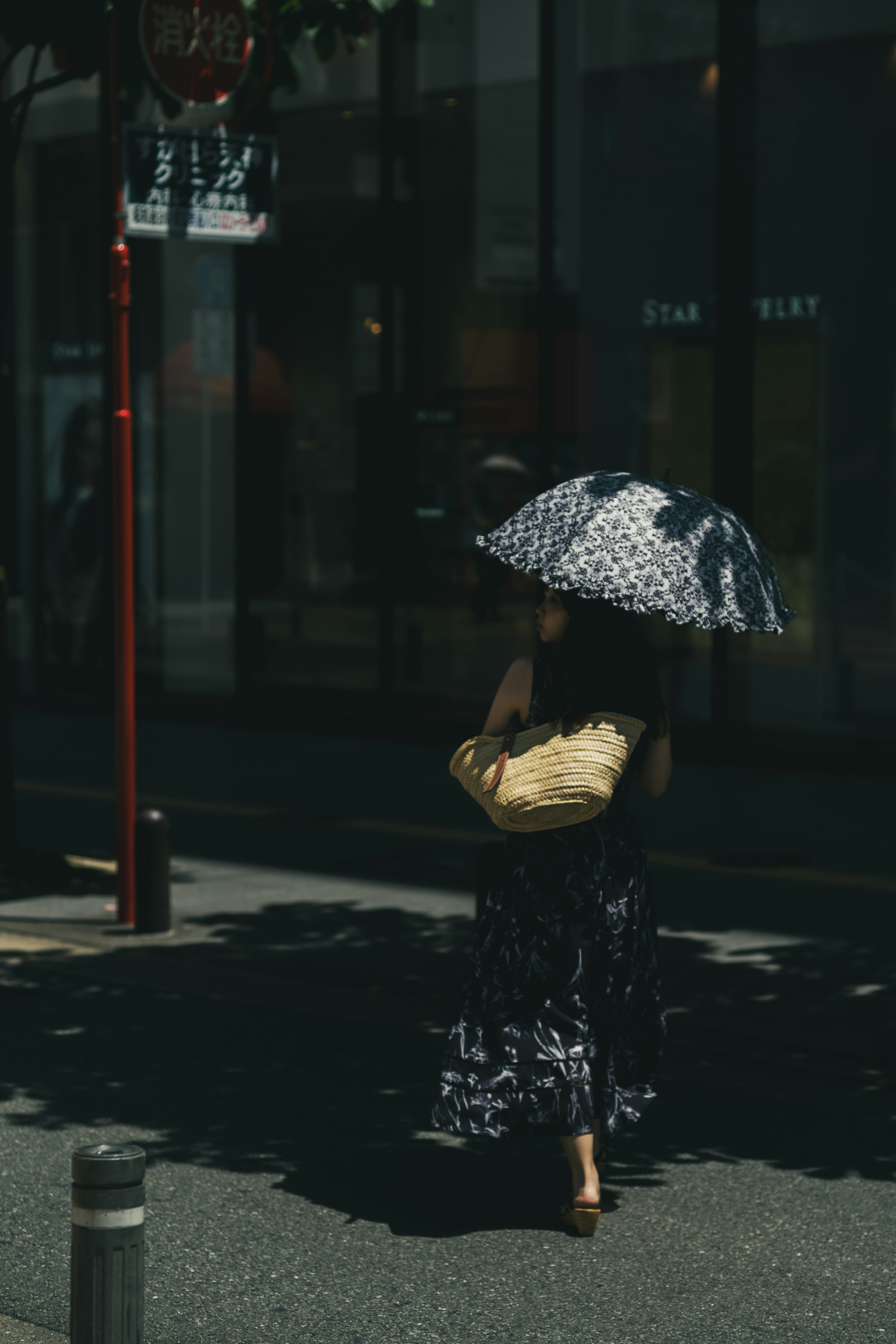 一位女士在城市中走路，手持圖案傘