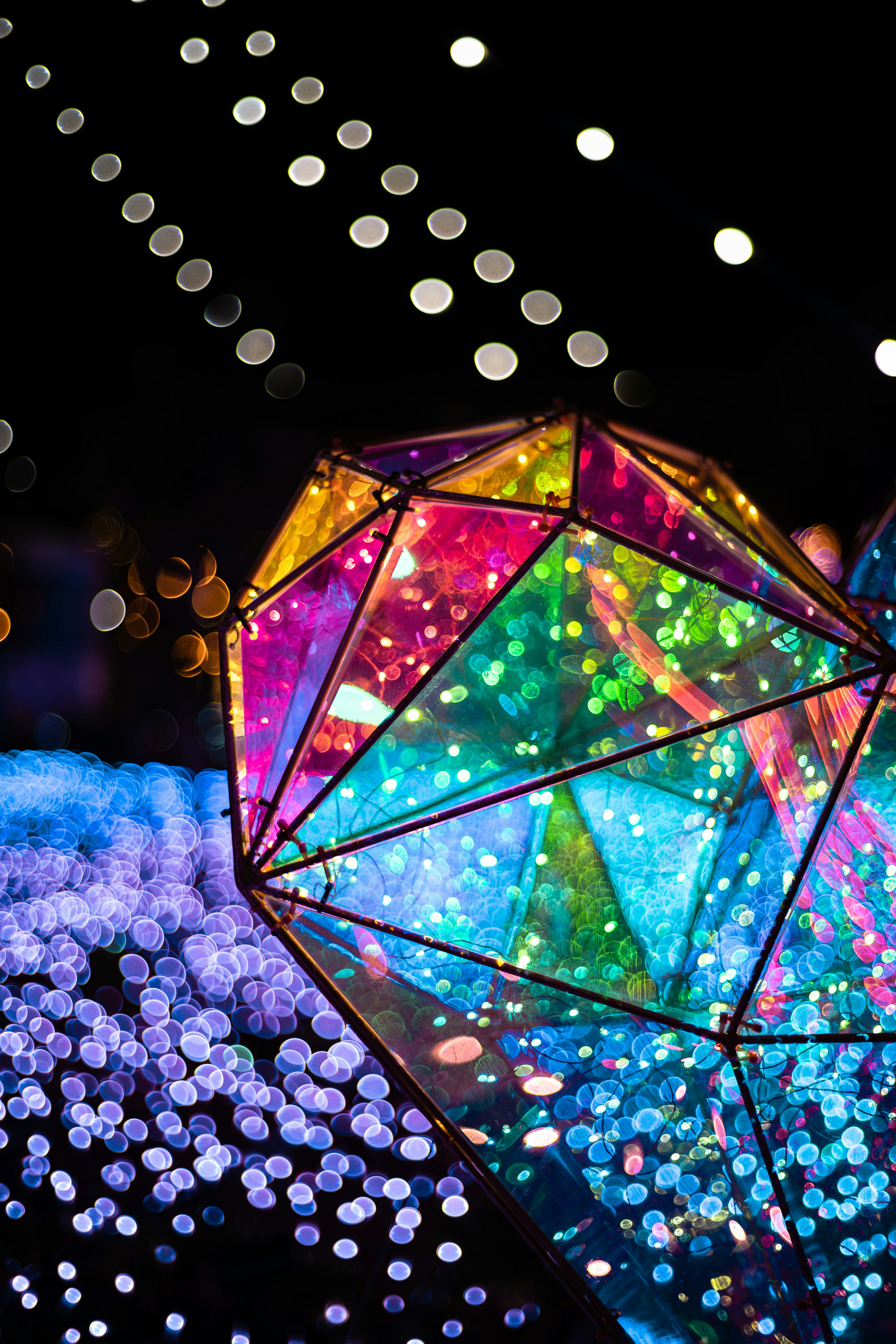 Colorful lighted diamond-shaped object shining in a night scene