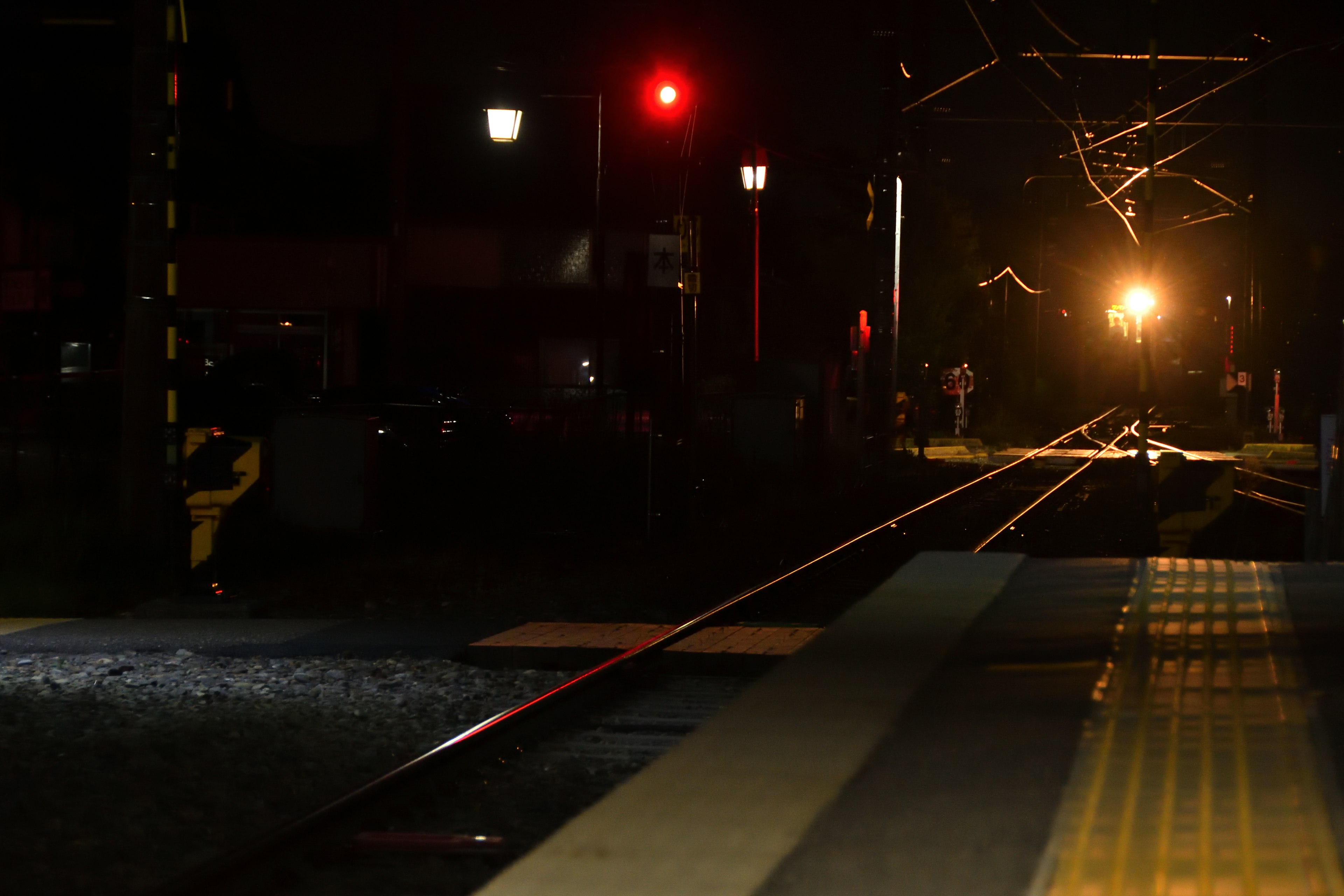 Escena ferroviaria nocturna con una luz roja iluminada