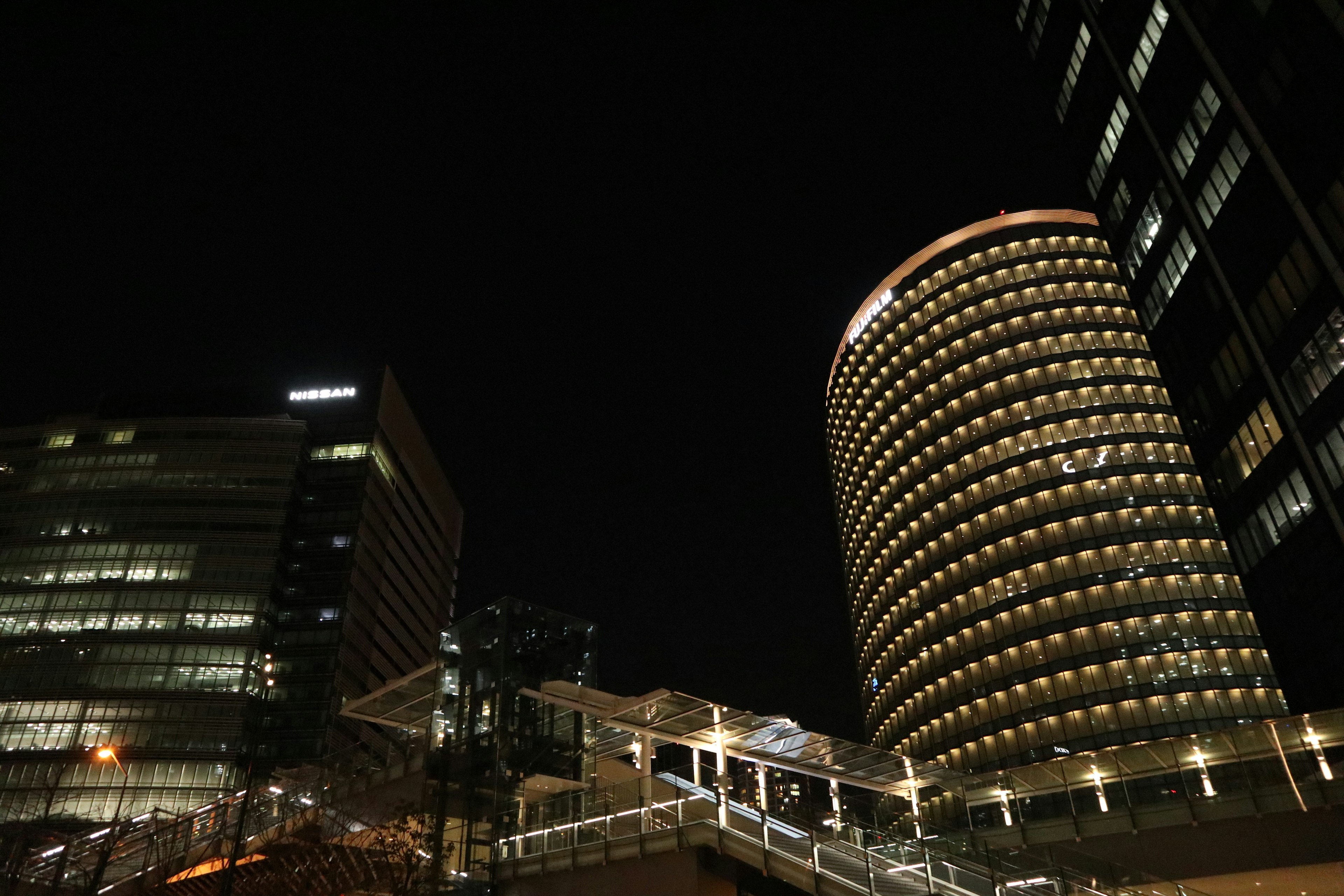 Night cityscape featuring skyscrapers and a walkway