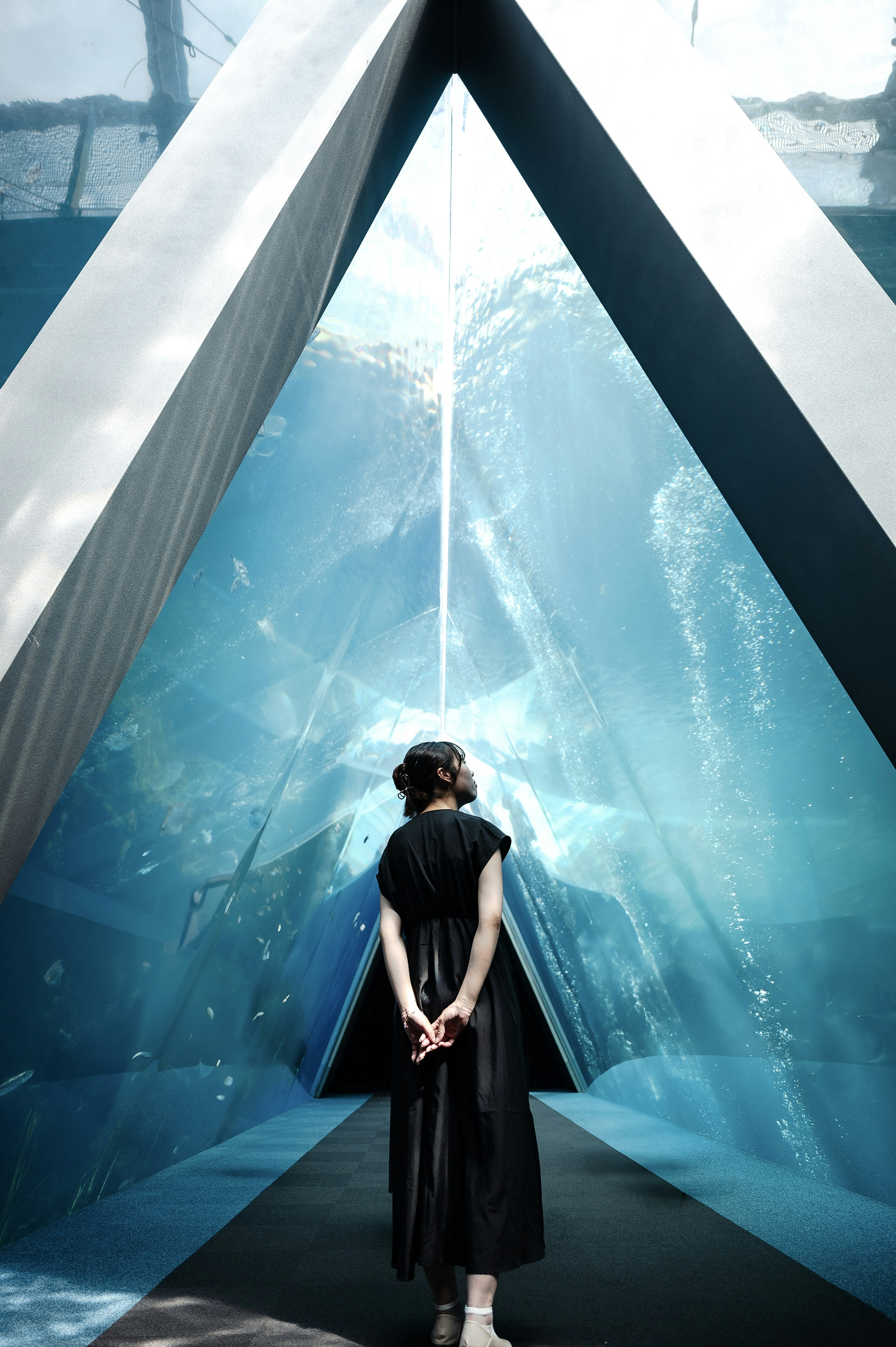 A woman standing in blue water with triangular structures